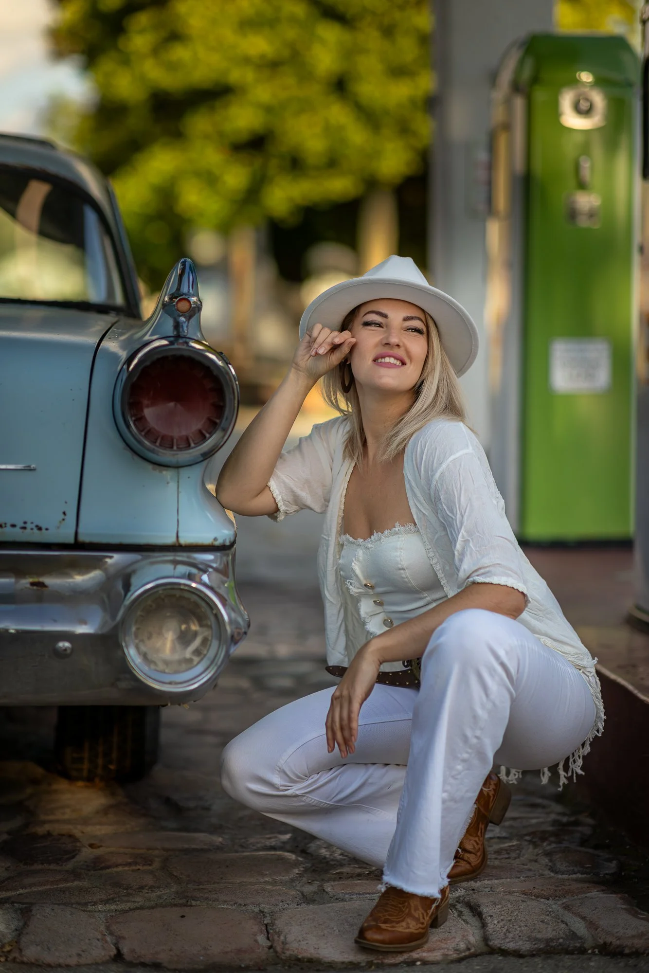 Woman in white Western outfit at Niles Flying A vintage gas pumps, mid-afternoon directional light, Fremont CA