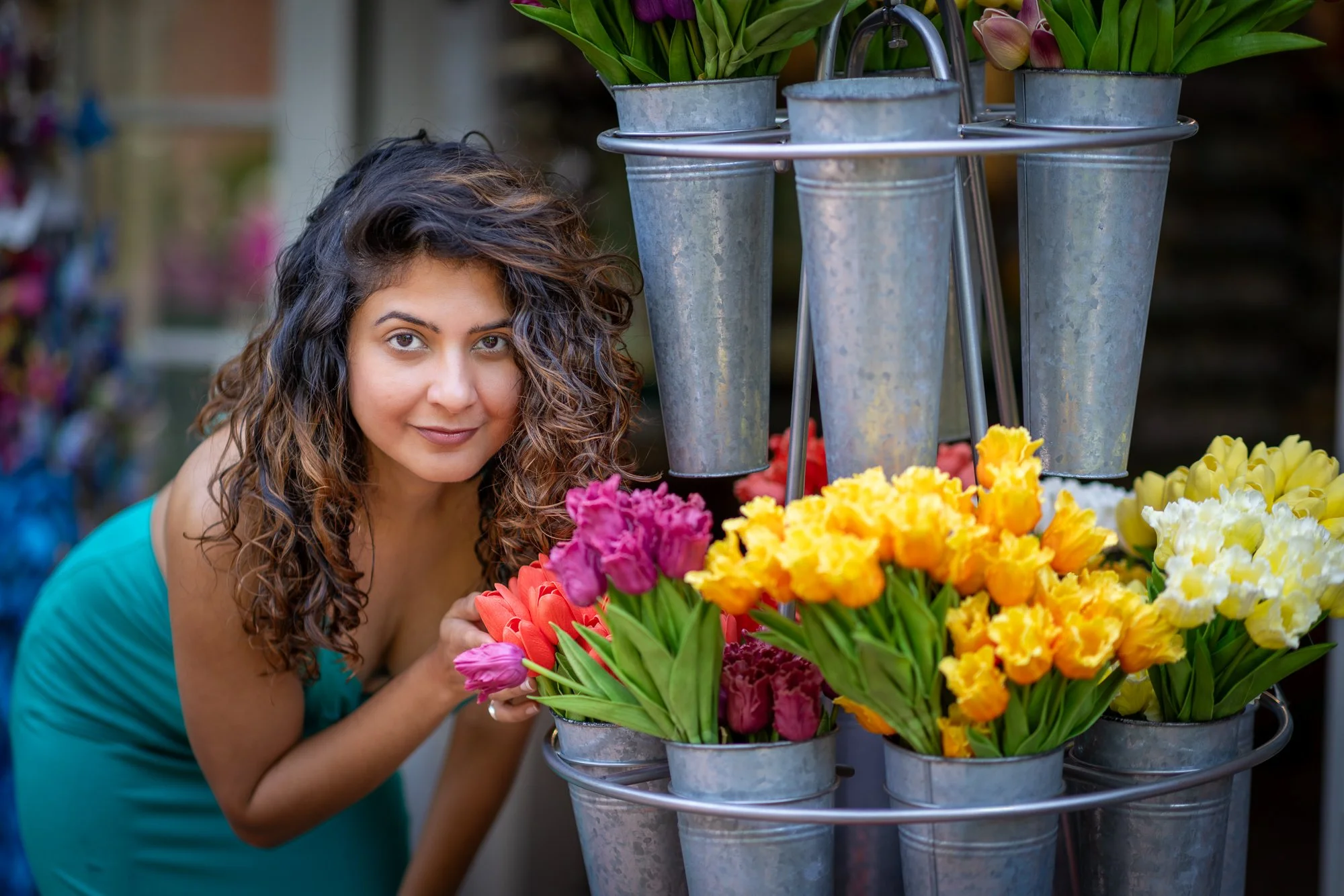 Woman with curly hair selecting colorful tulips at a flower stand.
