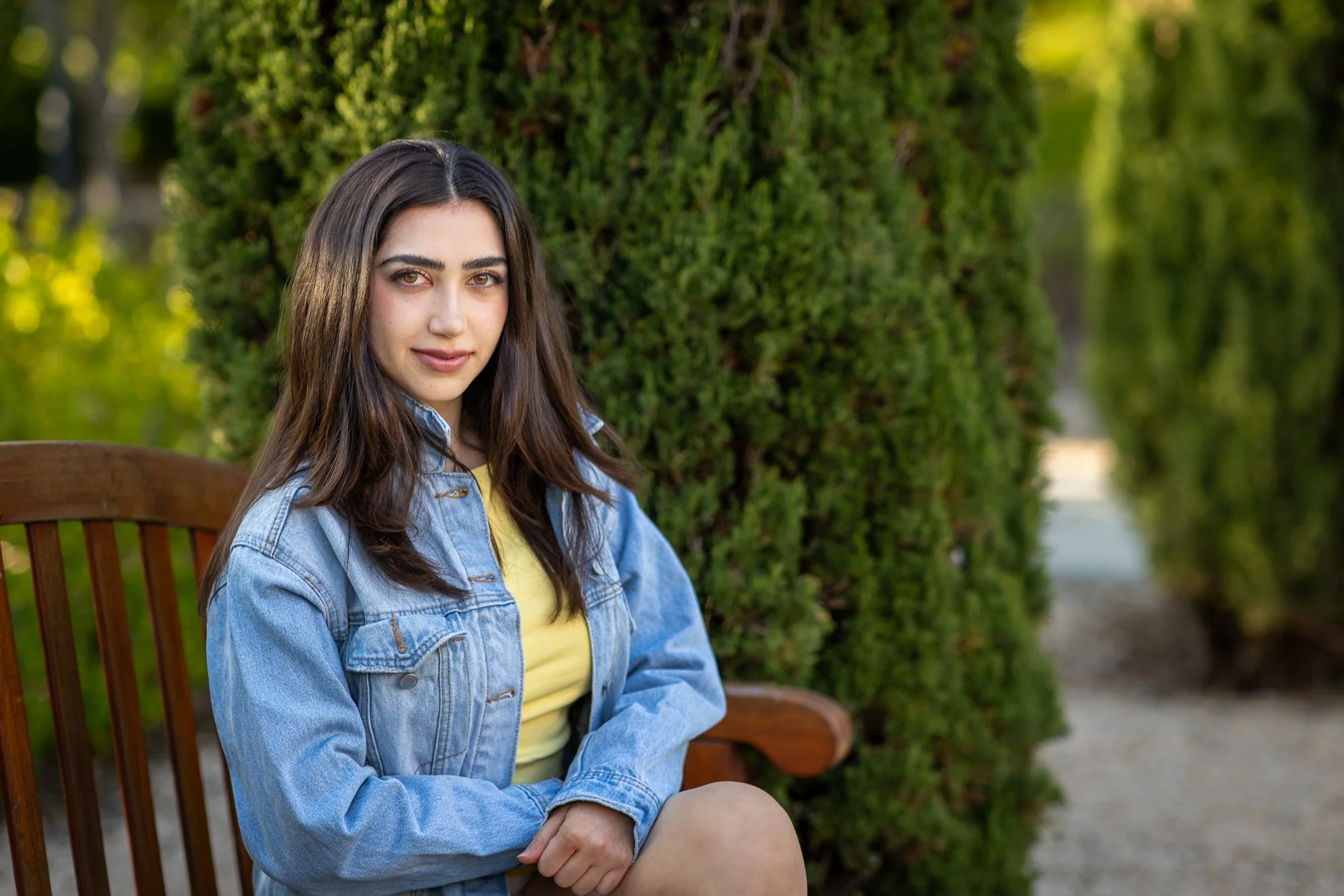 Close portrait of woman in denim jacket on garden bench at Stanford Cantor Arts Center, natural light lifestyle photography