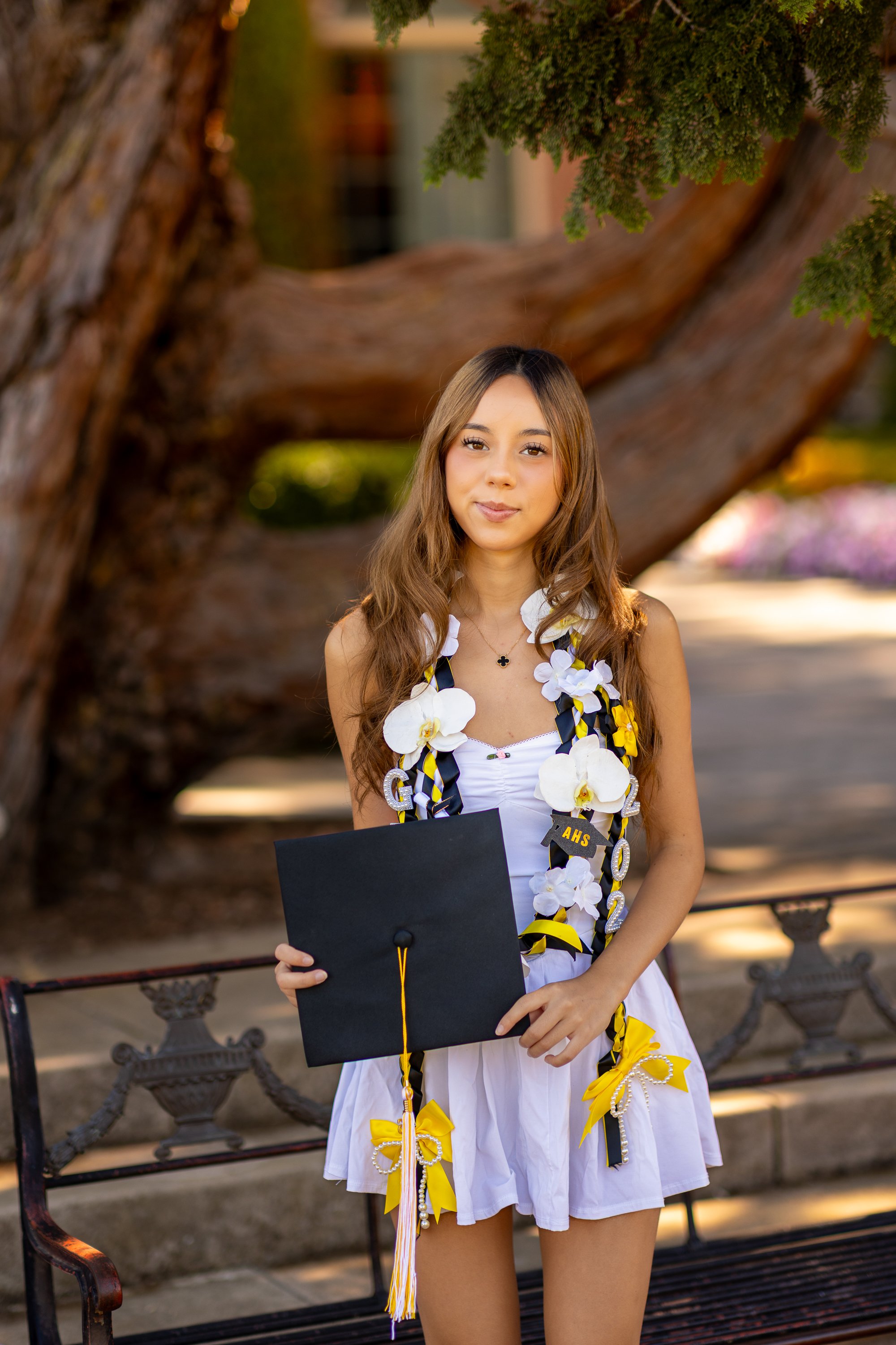 Senior holding graduation cap in front of her at Filoli Woodside portrait session
