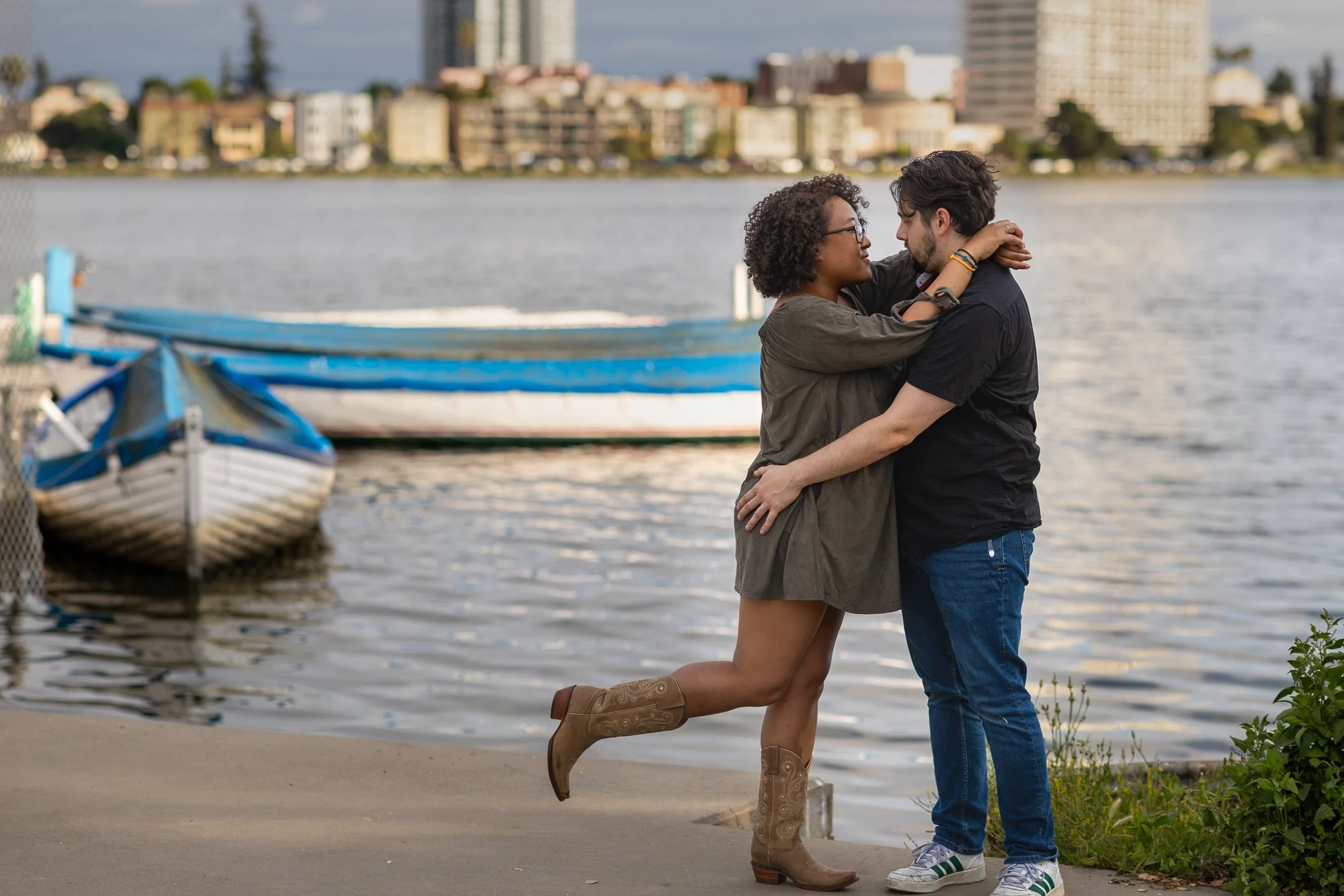 Bay Area couples photography playful dancing hug by lake with blue rowboat