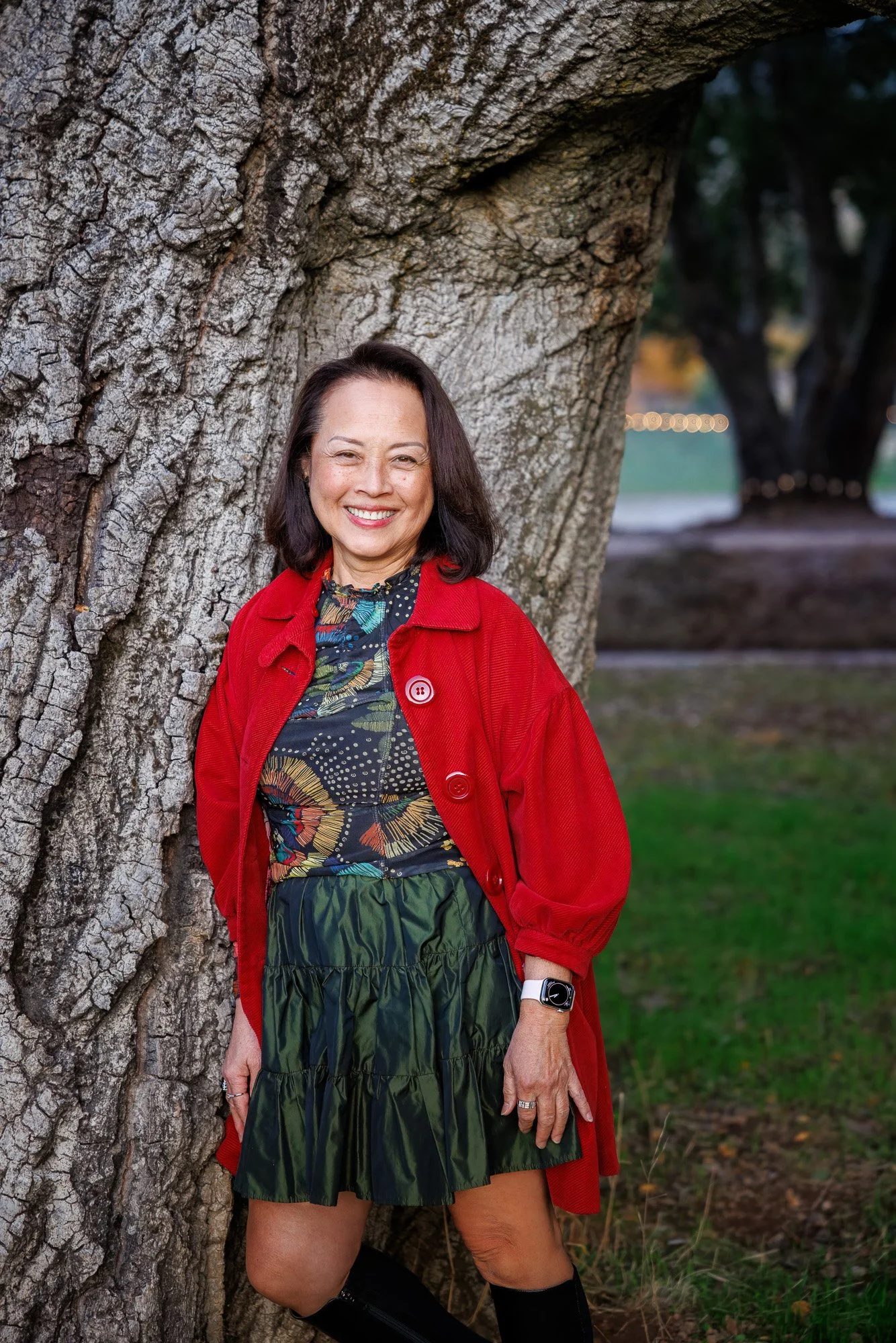 Woman in red coat leaning against large oak tree at Filoli Historic House and Garden Woodside California, natural light outdoor portrait