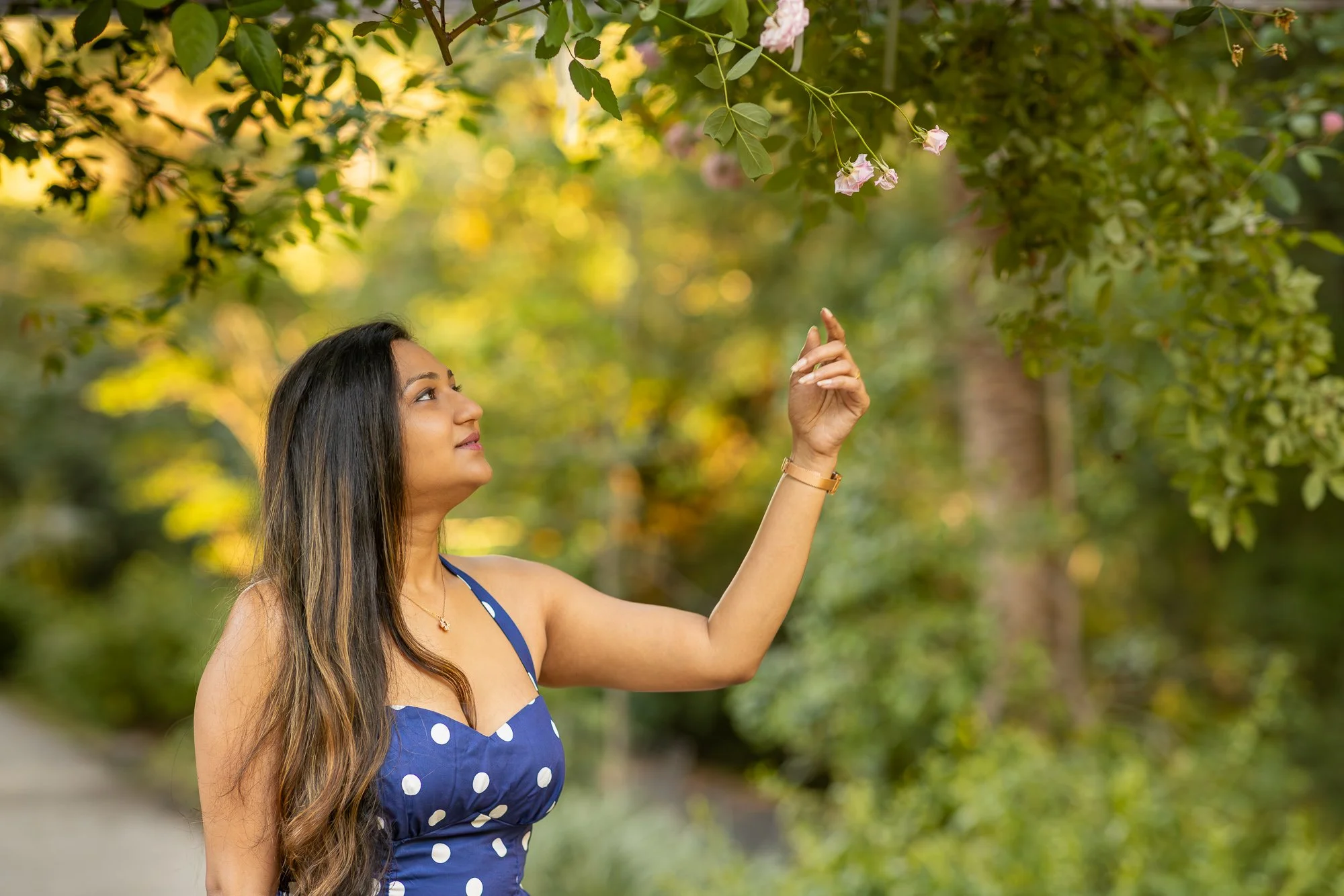 Woman in navy polka dot dress walking along forest trail at Villa Montalvo Saratoga, outdoor lifestyle portrait Bay Area