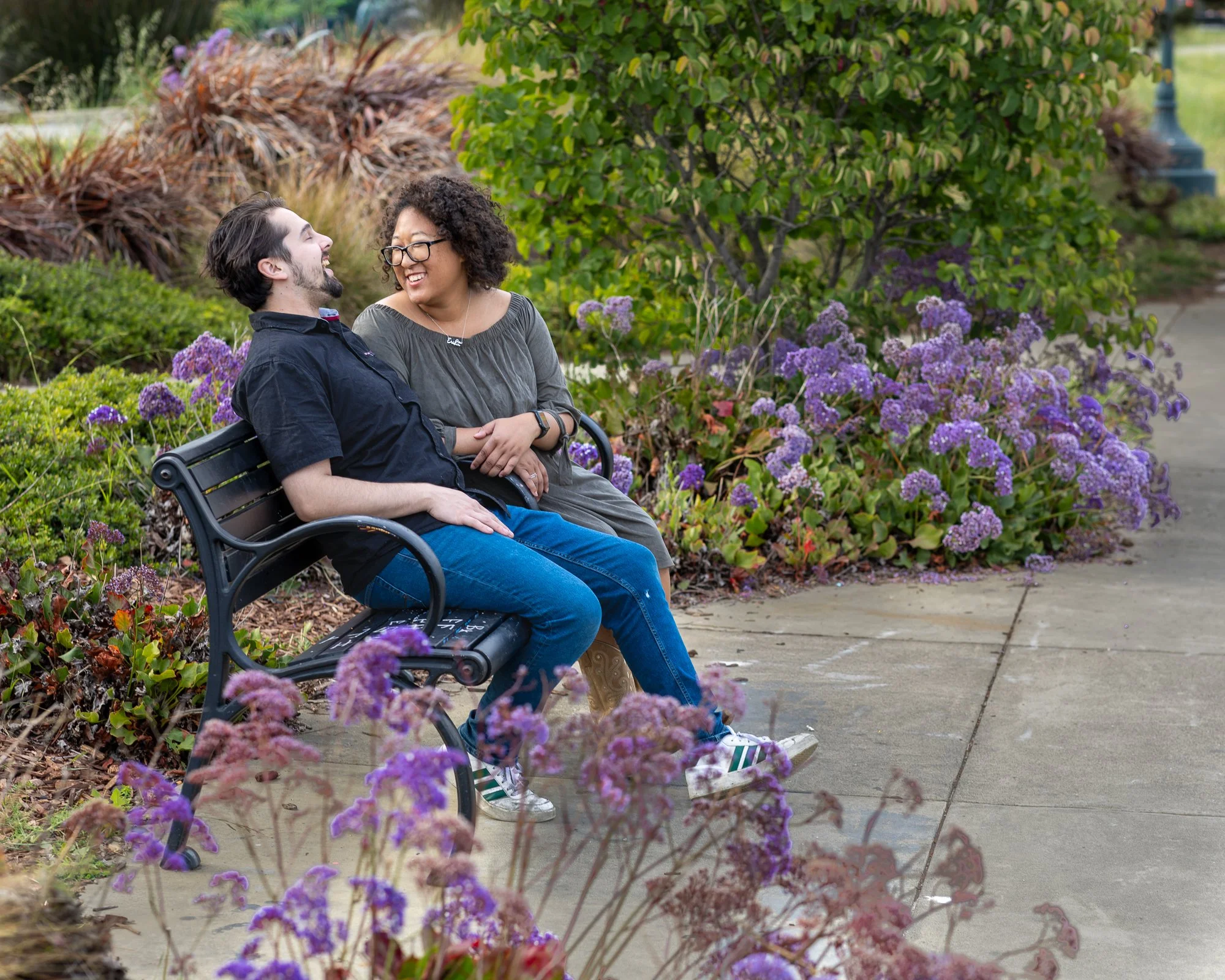 Bay Area couples photographer natural light portrait on bench with purple flowers