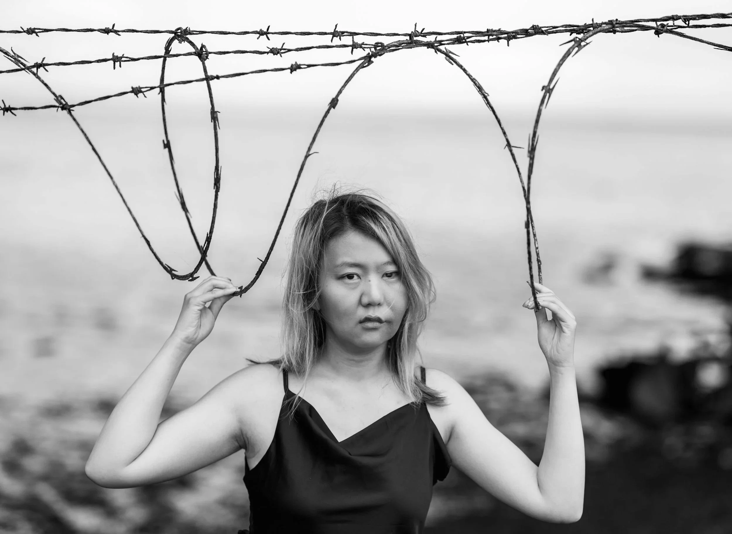 Woman in black dress next to razor wire at Dumbarton Bridge Bay Area Photoshoot