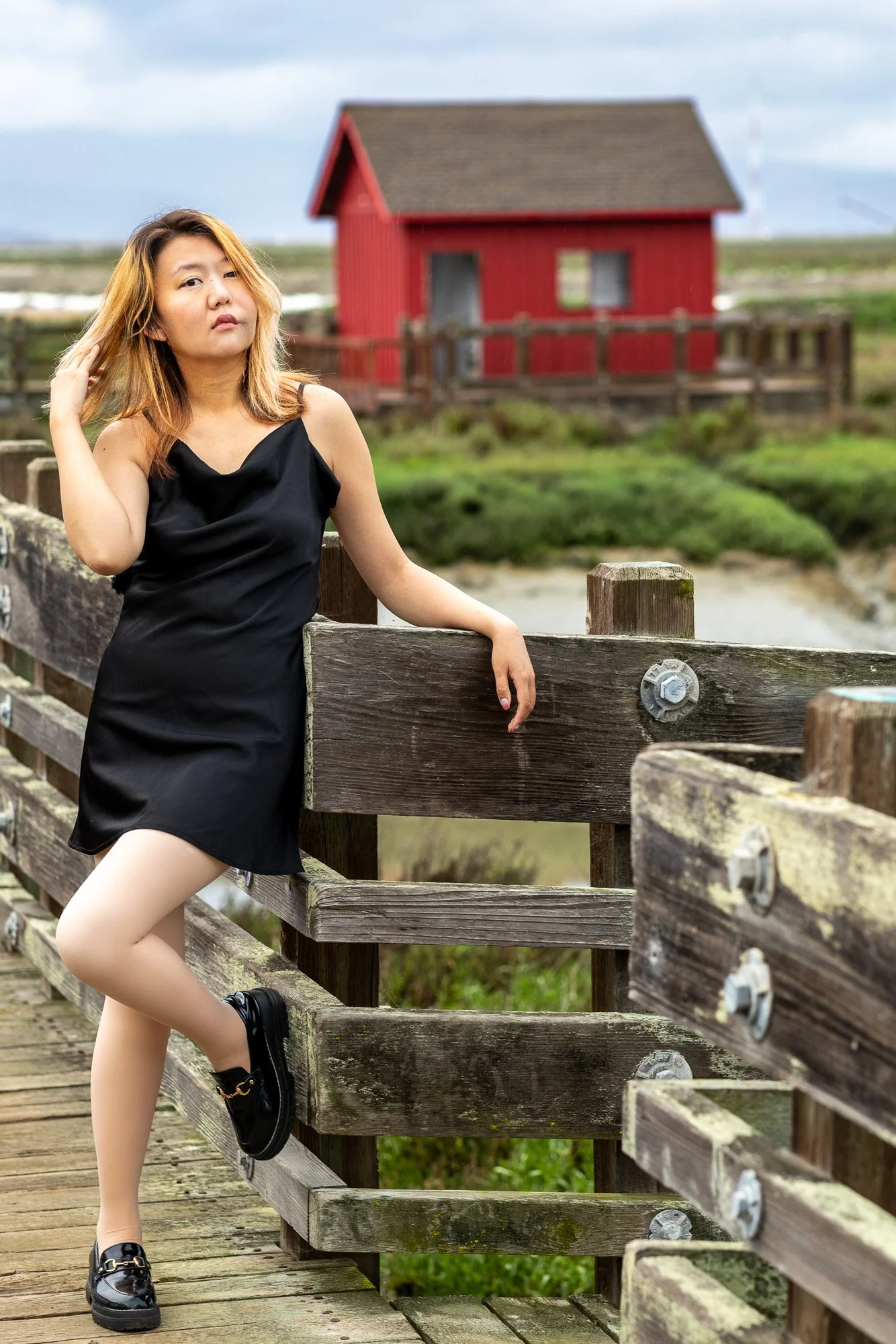 Woman in black slip dress standing on wooden boardwalk at Dumbarton Bridge Shoreline Trail Newark, Bay Area personal lifestyle photography