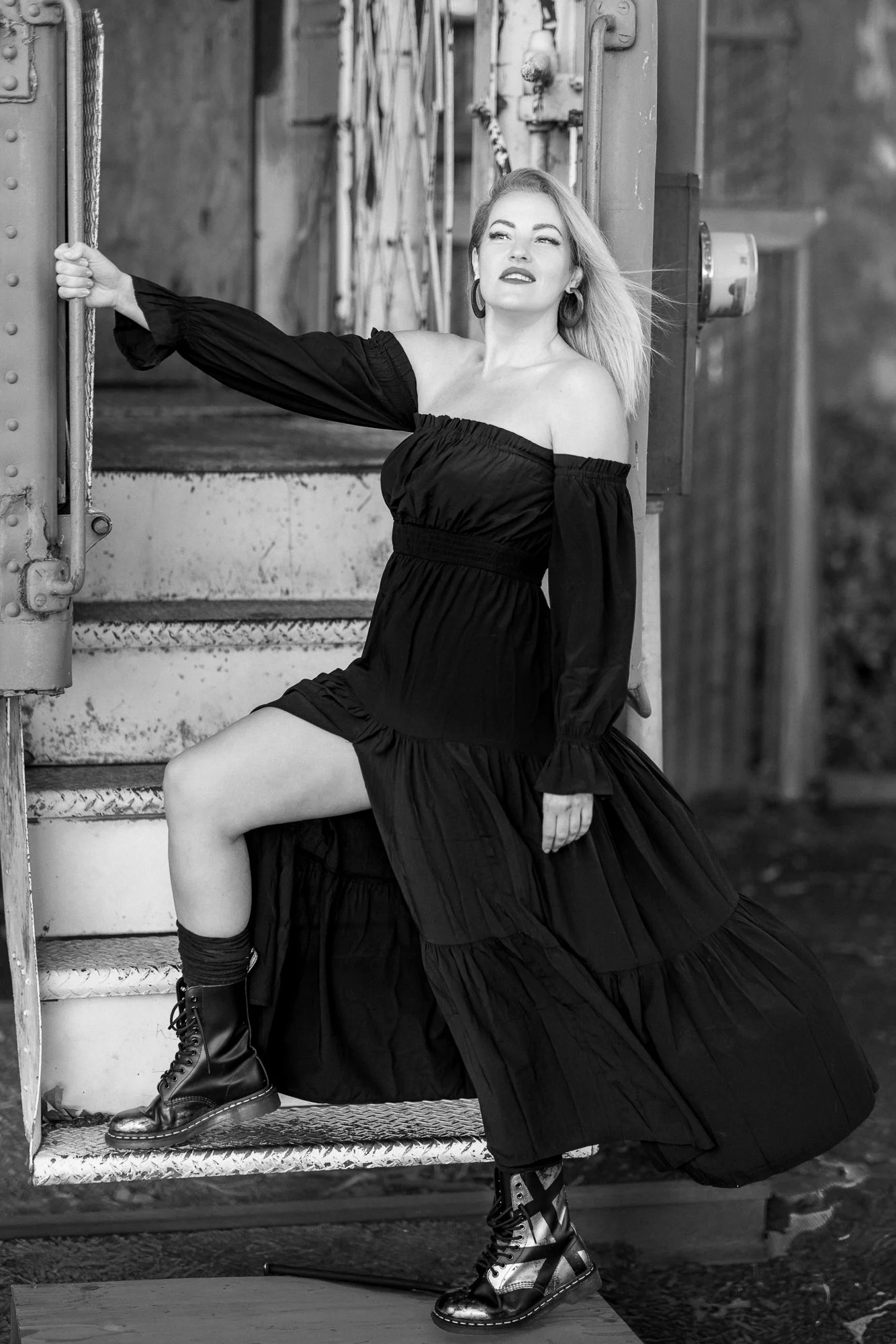 Woman in black off-shoulder dress leaning from vintage railcar doorway, Niles Canyon Railway depot, Fremont CA