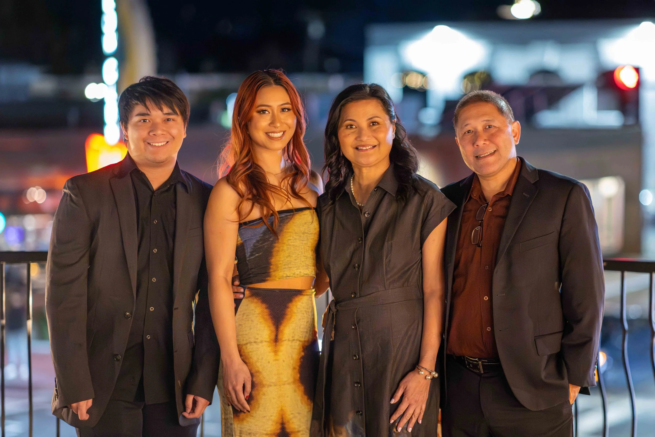 Family shot in Bay Area restaurant birthday party photography session - street lights behind lighting the scene