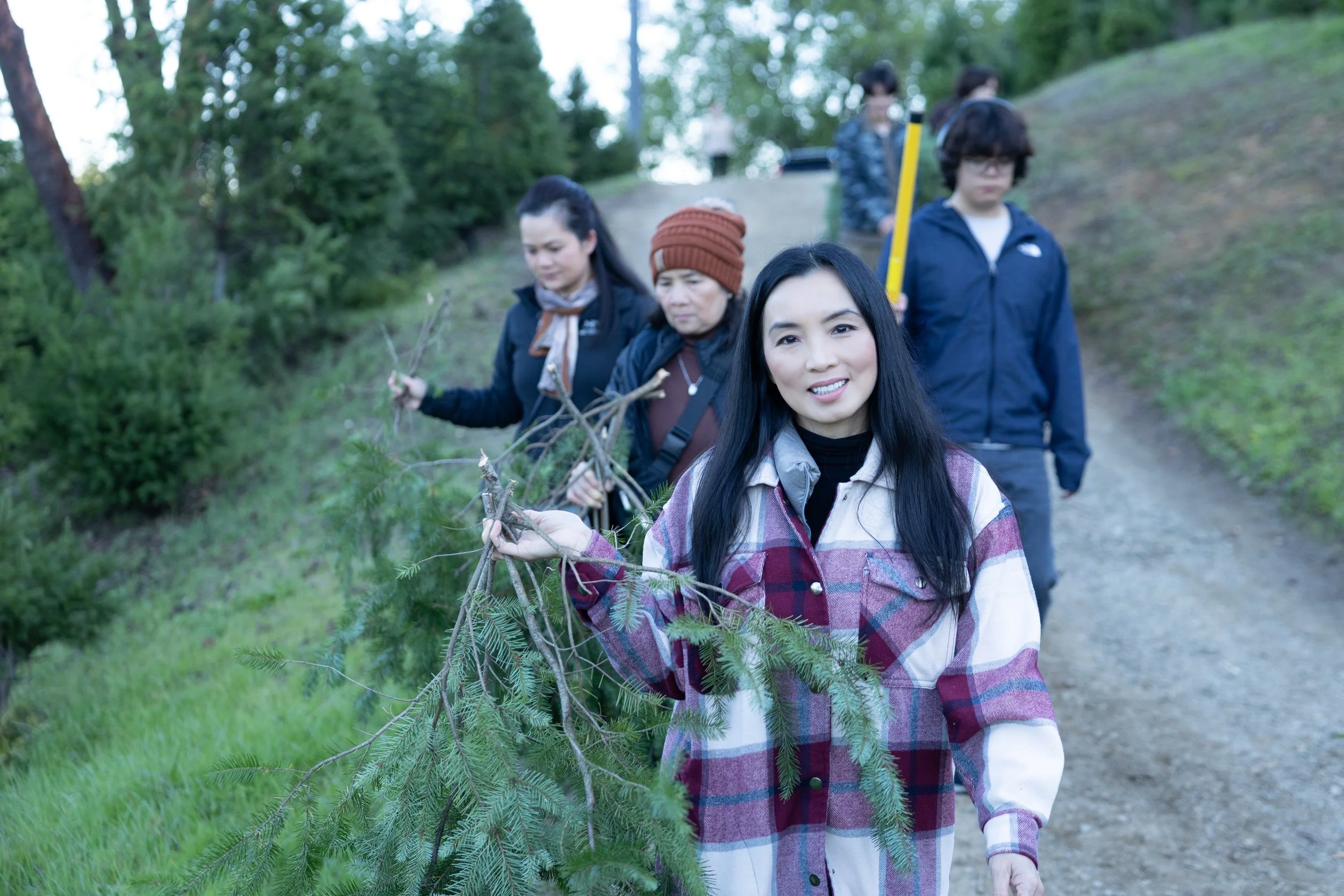 person carrying pine branch on shoulder forest trail Radonich Ranch