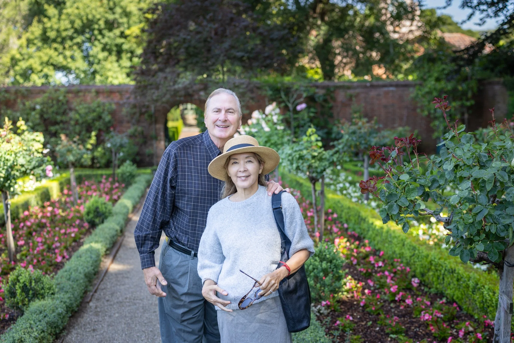 Couple in the walled rose garden at Filoli among boxwood beds and summer roses, Woodside