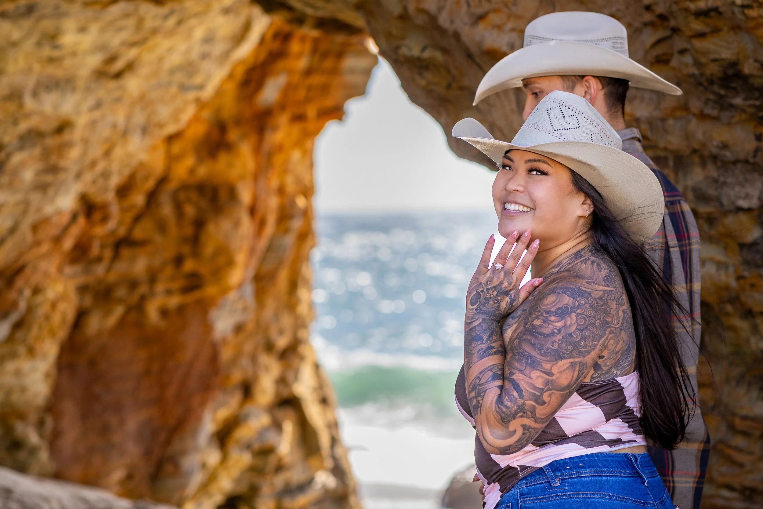 Fiancée showing her ring inside the Hole-in-the-Wall arch at Panther Beach, Santa Cruz