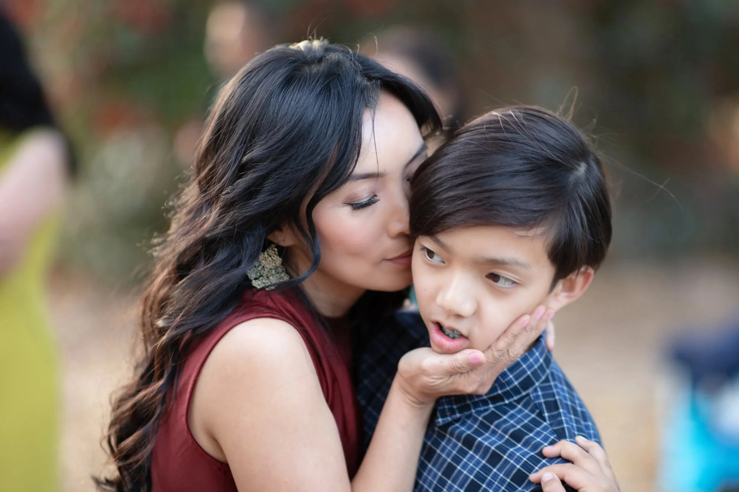 Mother kissing her young son's temple during an intimate Bay Area family portrait session