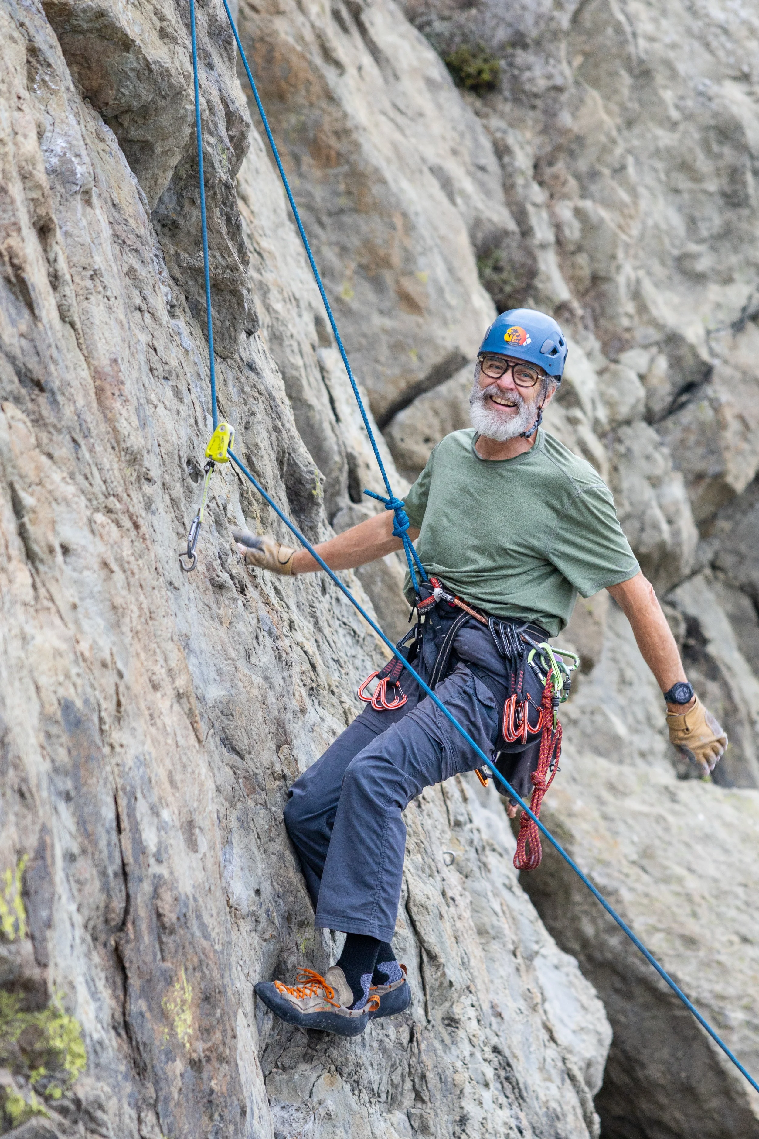 man gripping sandstone holds on rugged coastal crag at Mickey's Beach, Marin County