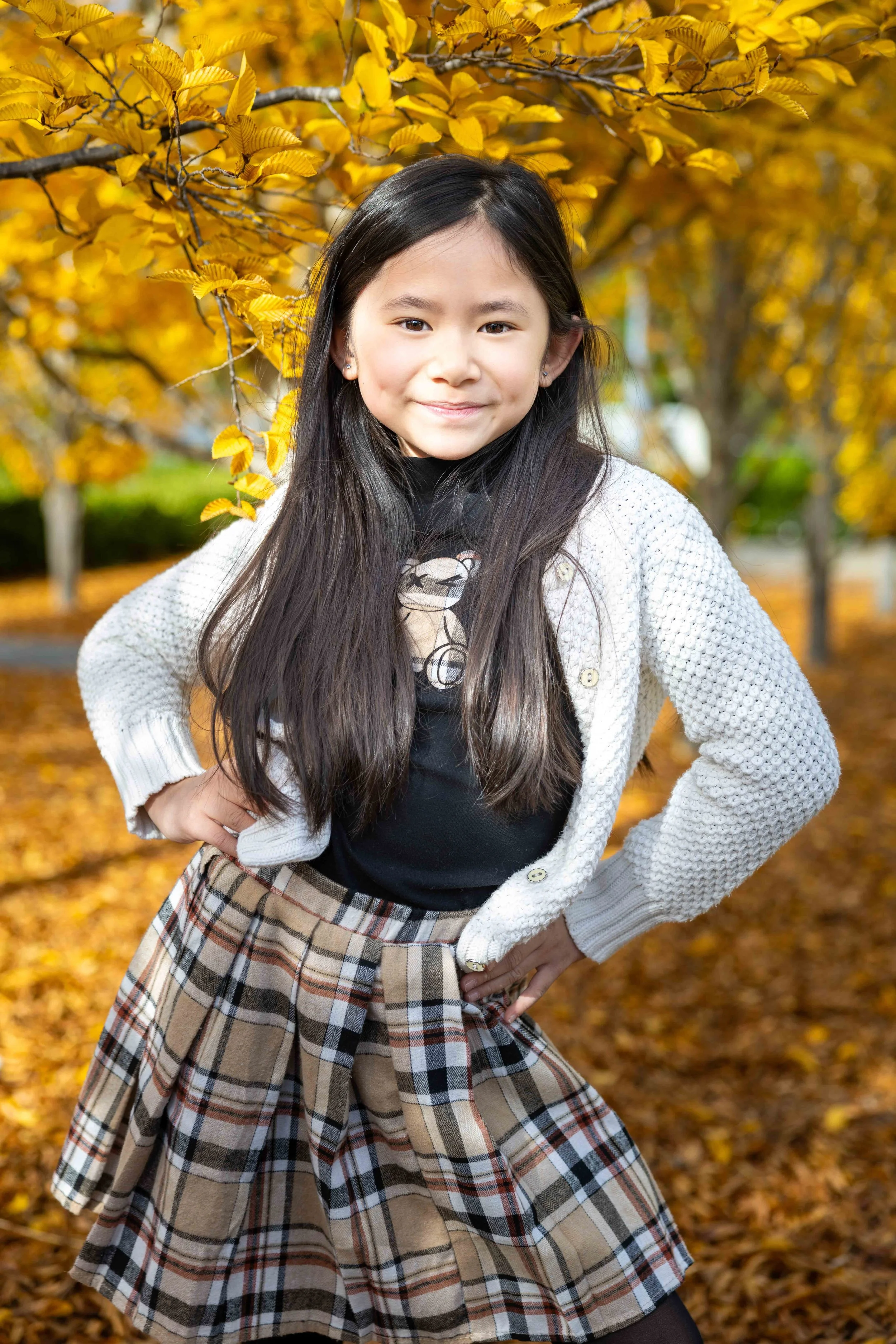 School-age girl in plaid skirt and white sweater at a Bay Area autumn family photography session