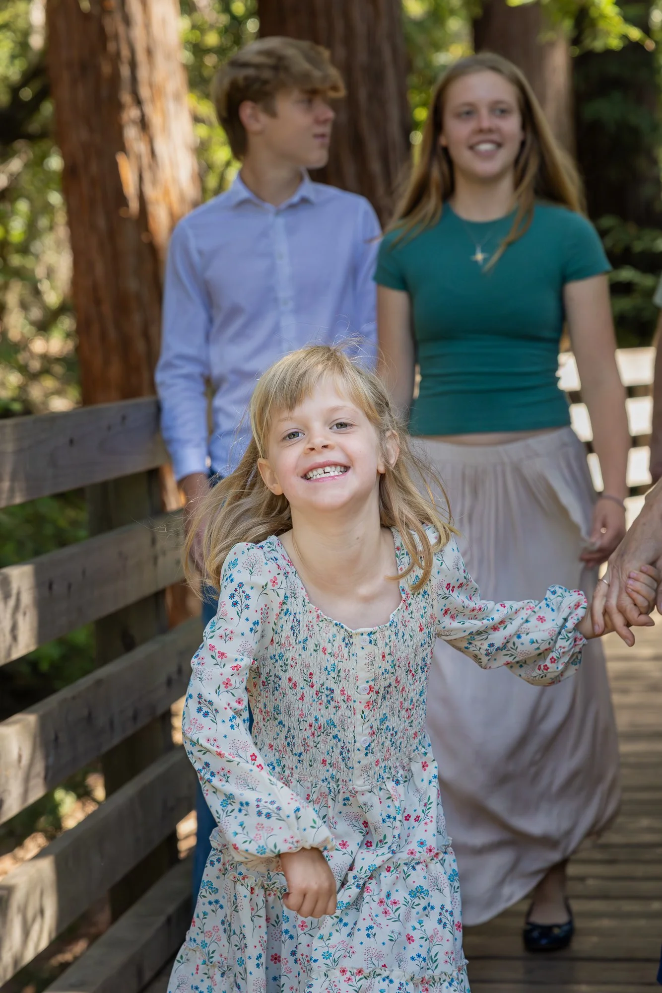 Family walking wooden footbridge at Shoup Park Los Altos, child laughing
