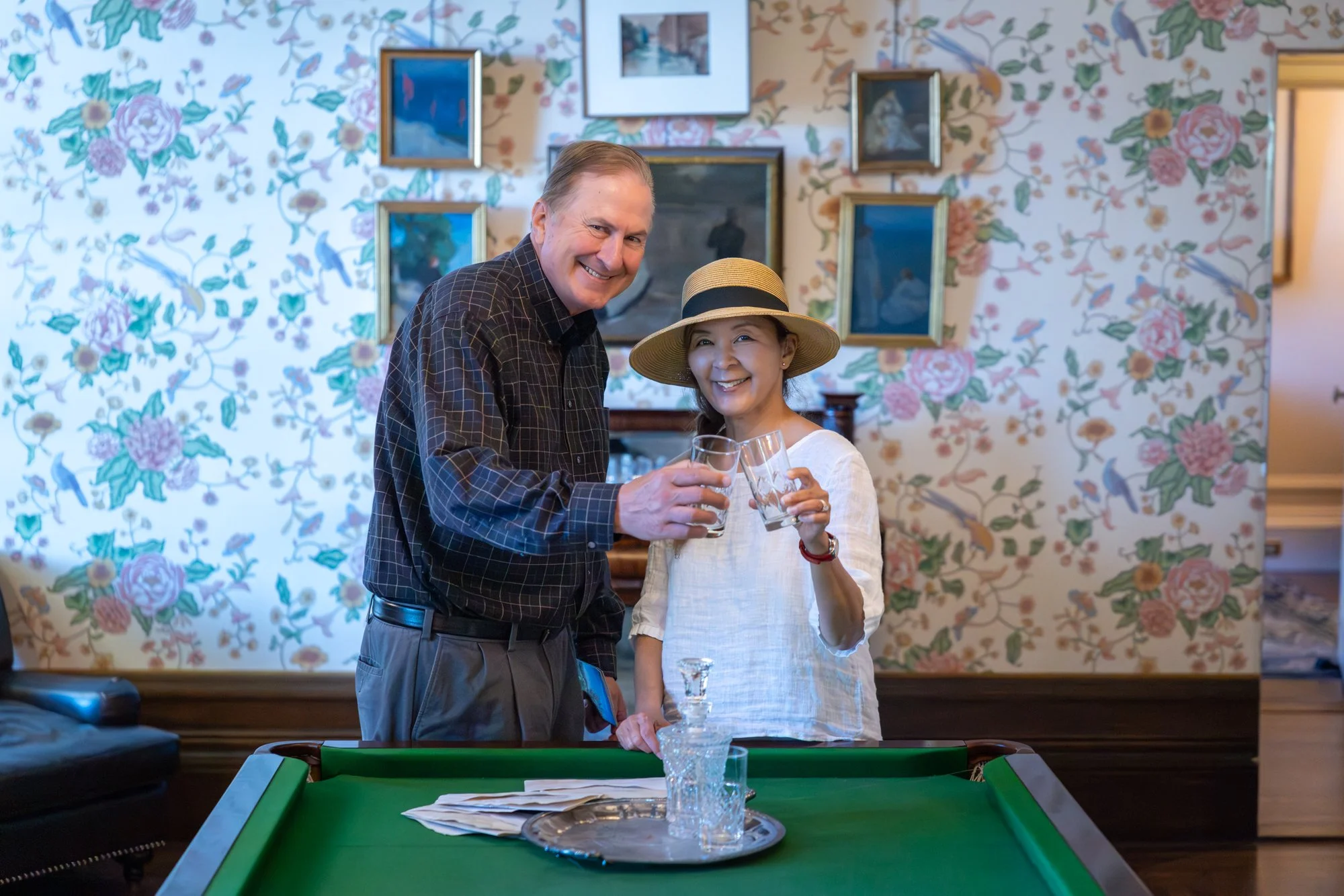 Couple raising a toast in the Filoli historic house billiard room interior, Woodside California