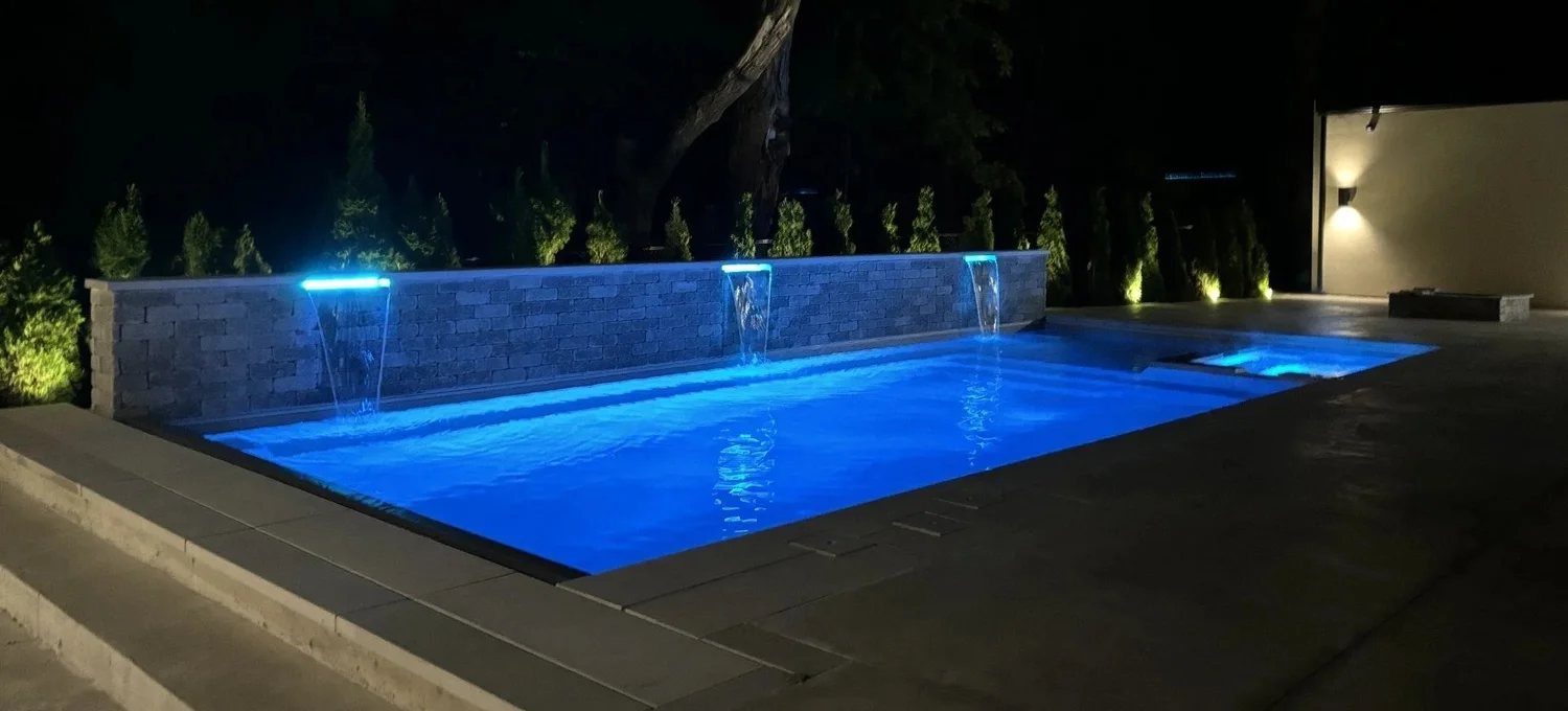 Pool and surrounding patio lit at night