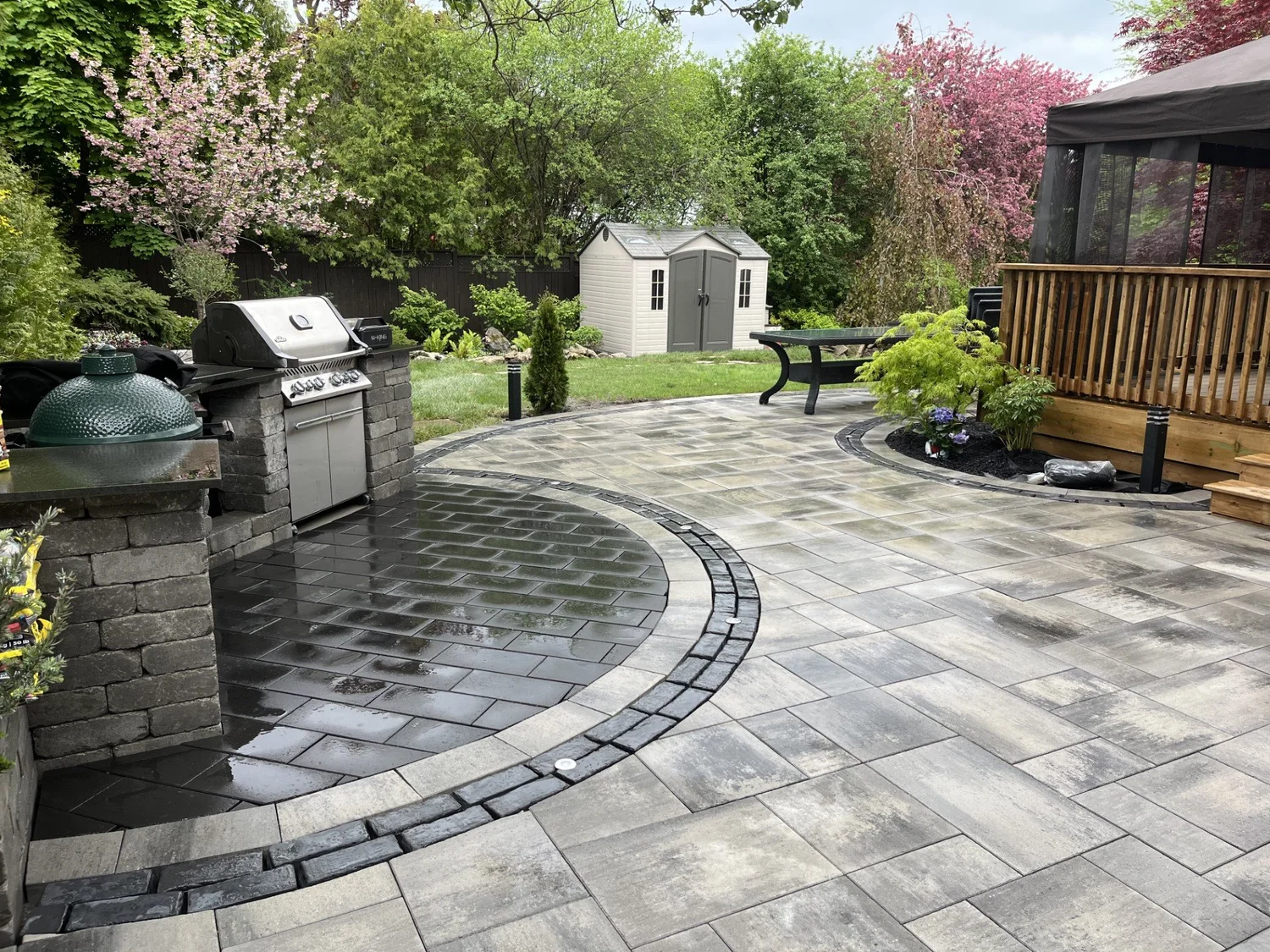 Backyard patio with circular inlay and outdoor kitchen
