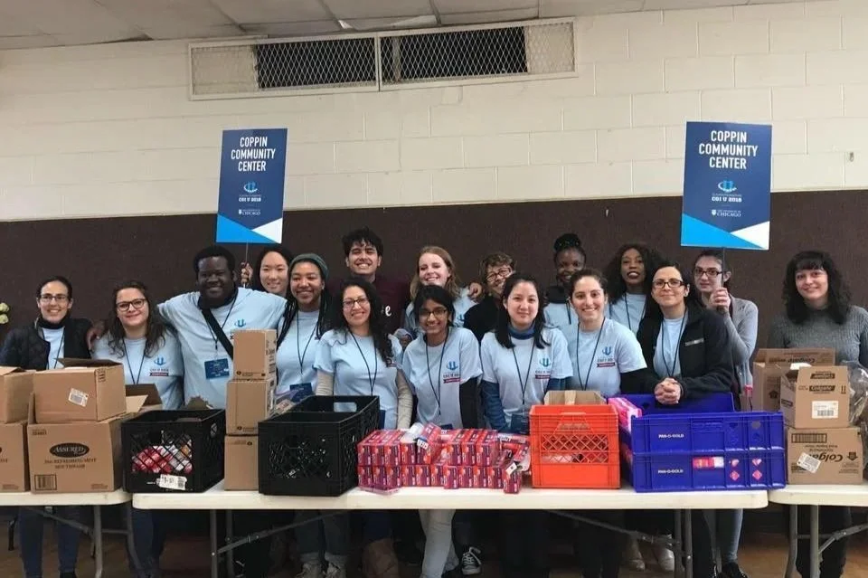 Group of volunteers at a community center packing boxes of supplies for a charitable event.