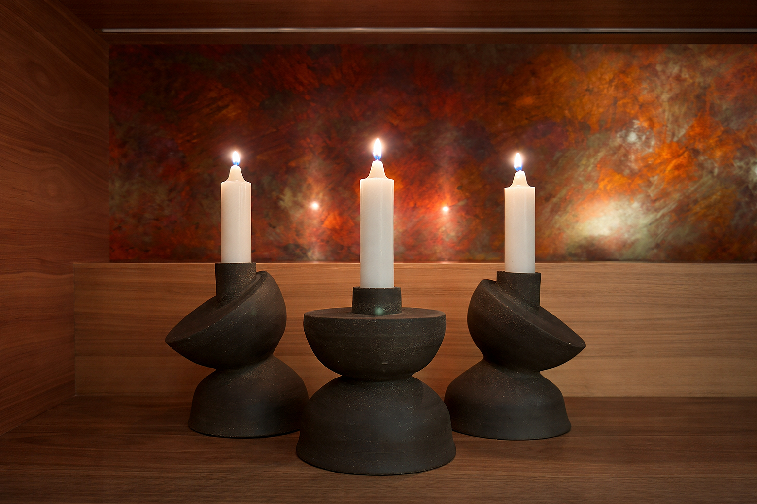 Asymmetric and modern charcoal grey ceramic candle holders.