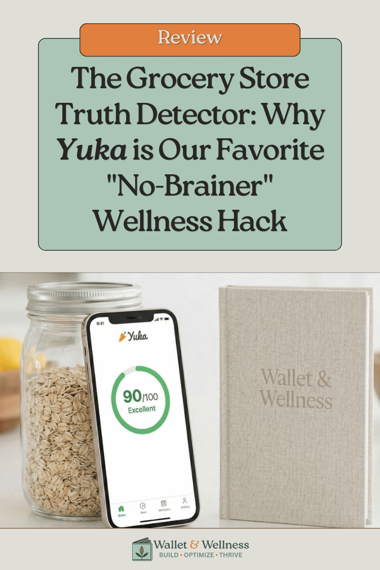 A smartphone displaying a high Yuka app health score on a kitchen counter next to a Wallet & Wellness branded notebook.
