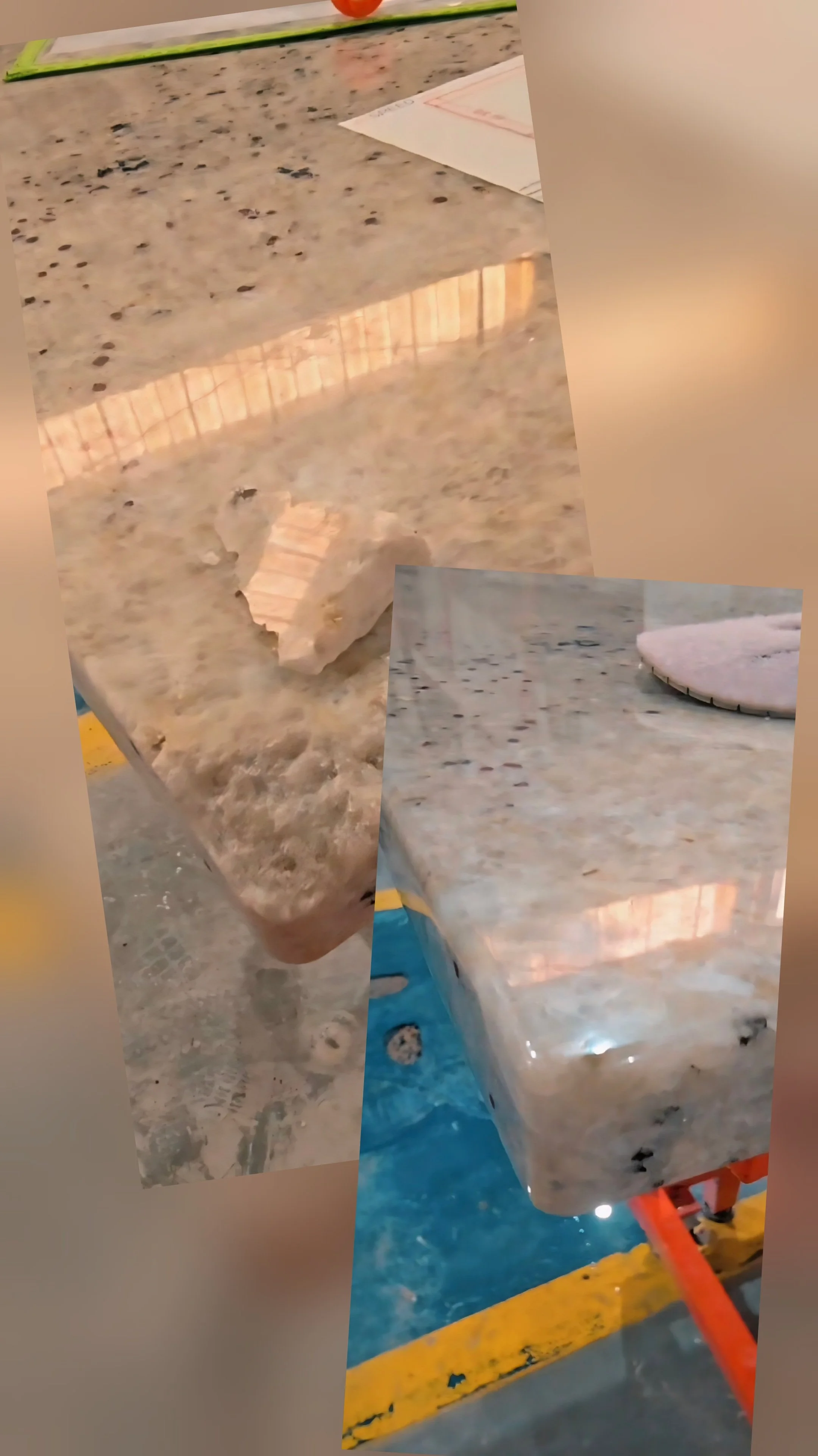 Multiple pieces of granite countertops on a concrete and yellow-painted surface, with some tools and paper in the background.