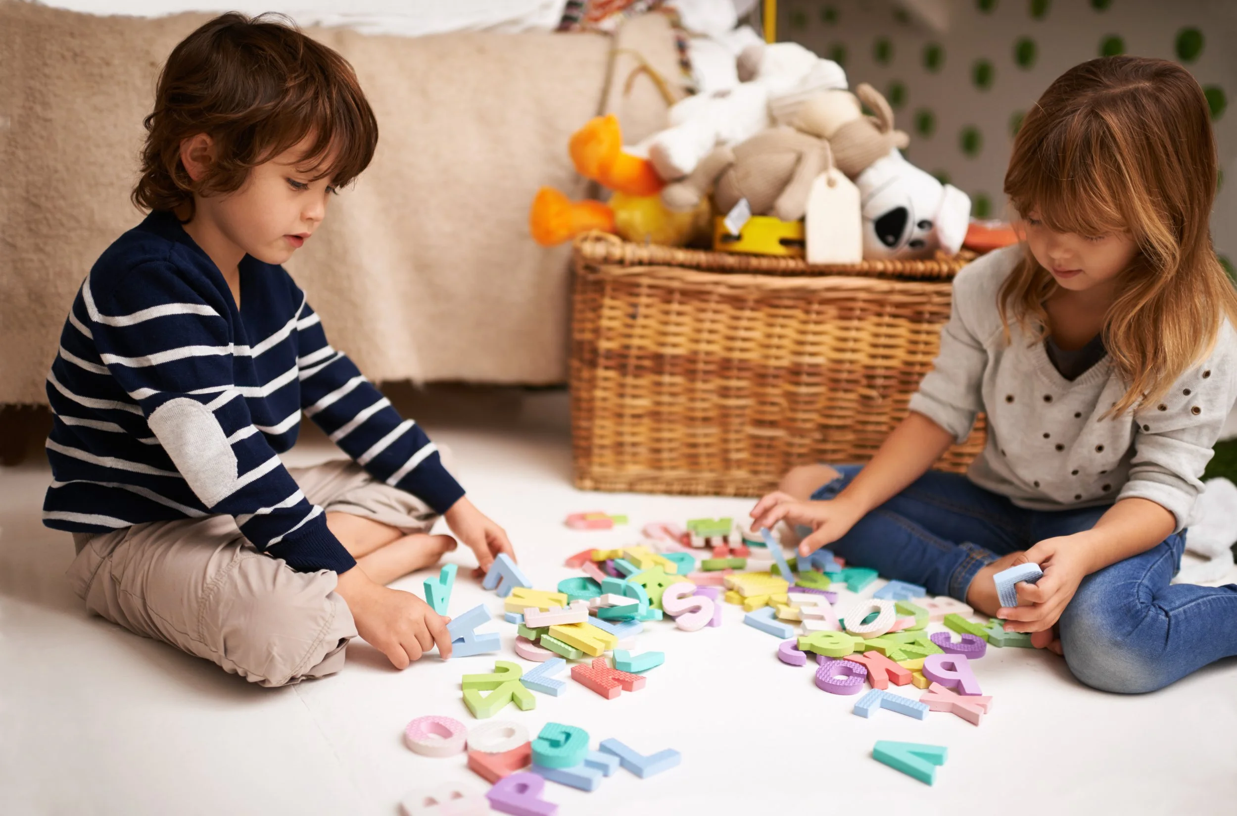 Children playing with alphabet letters as a fun literacy learning activity