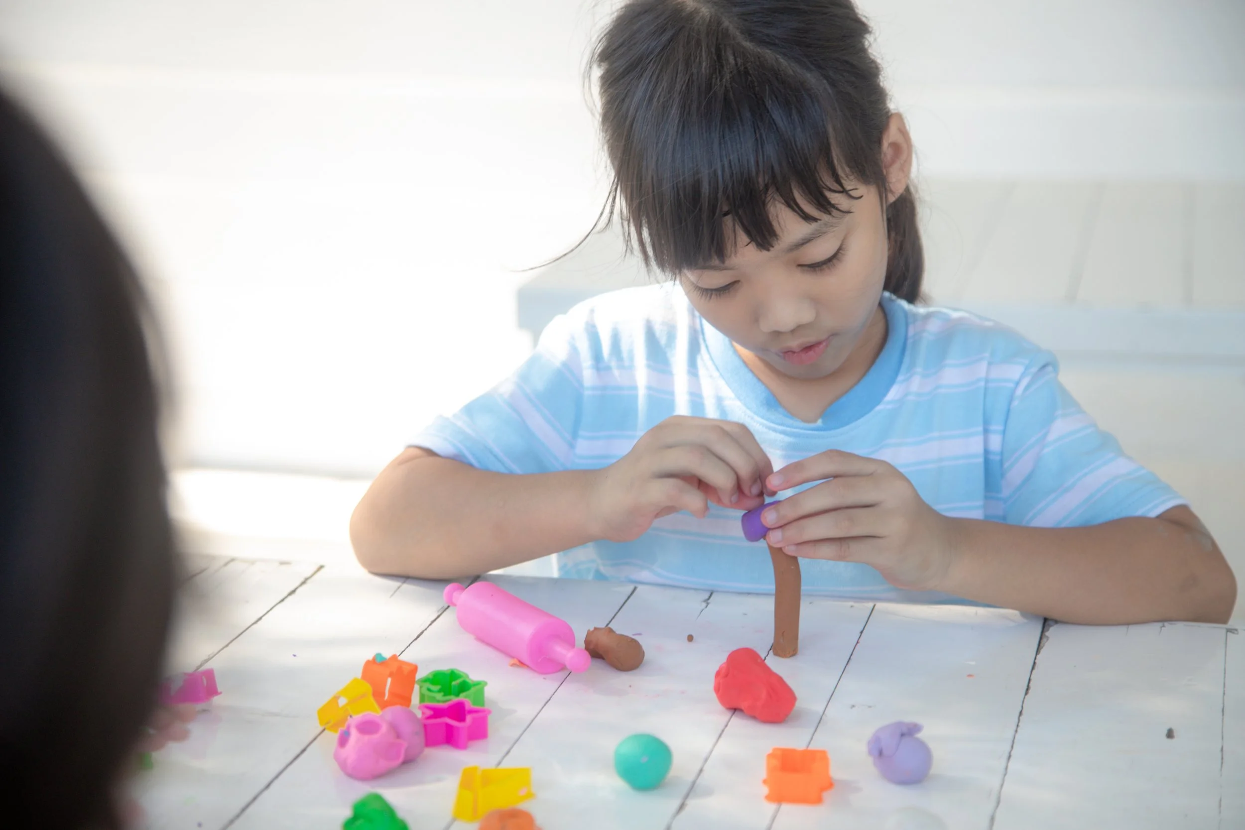 Child playing with play dough to develop sensory and fine motor skills