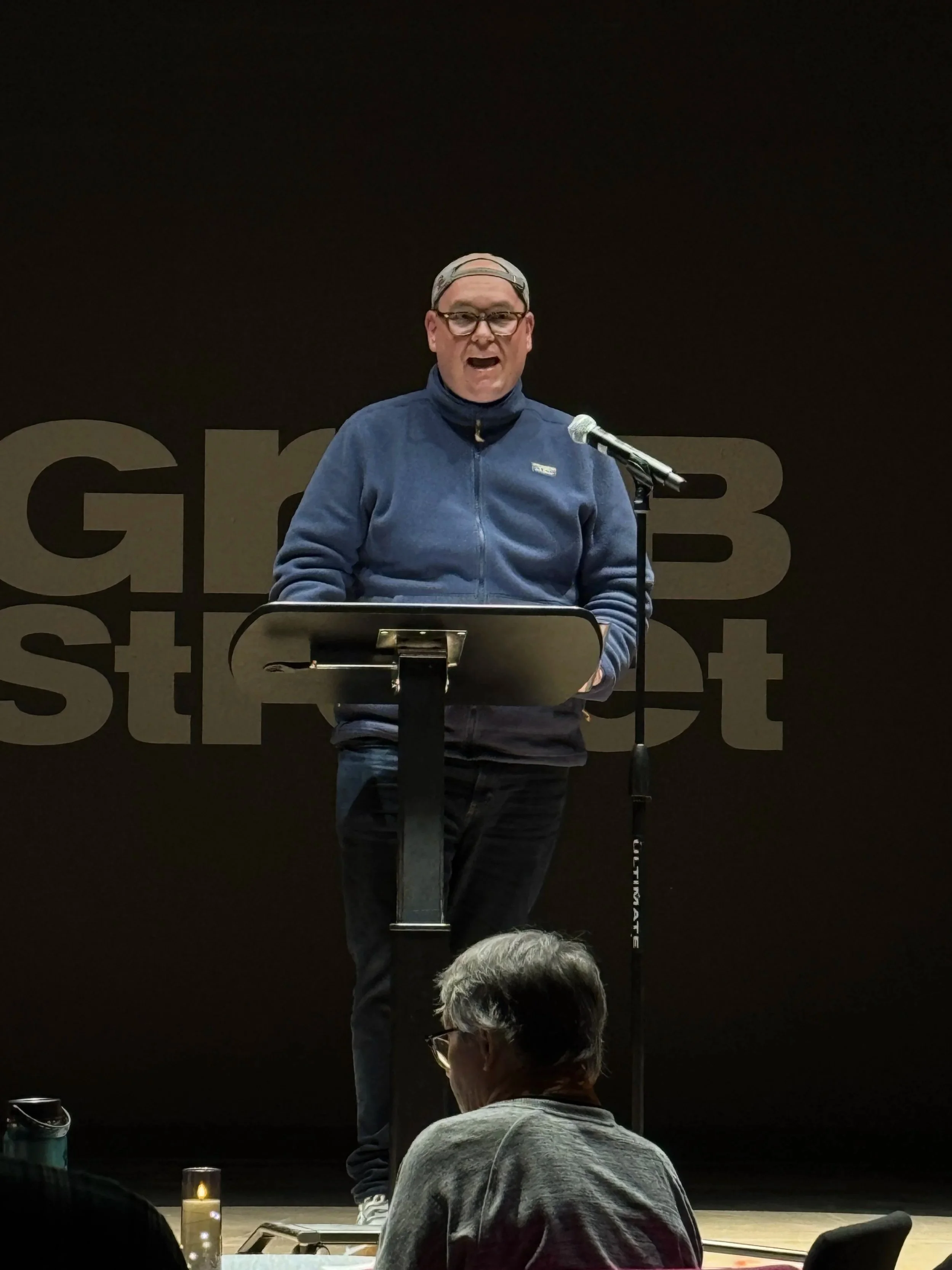 Jeff Robinson speaks on stage at a Grub Street event.