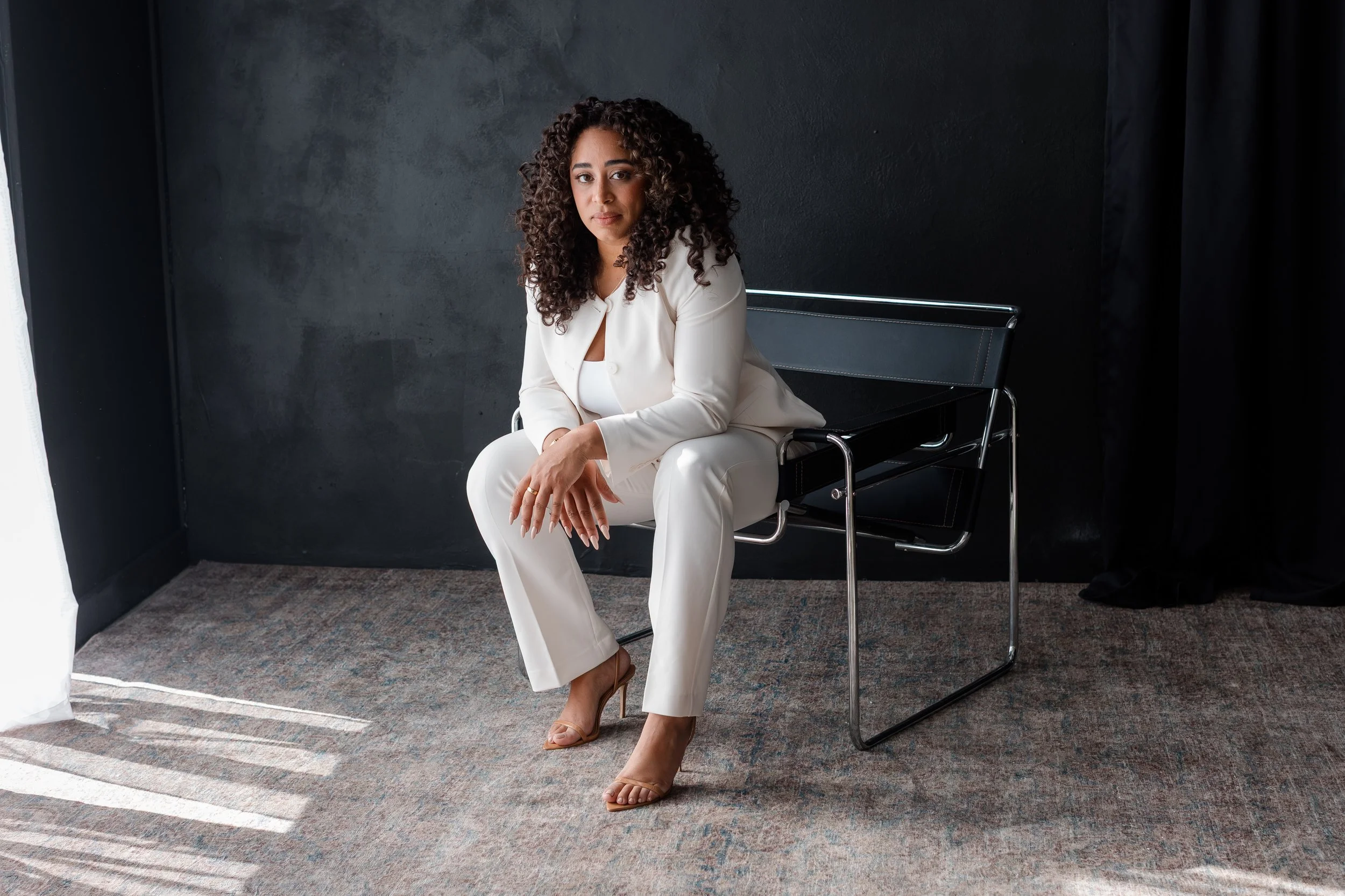 Professional woman posing naturally in a bright, airy creative studio space.