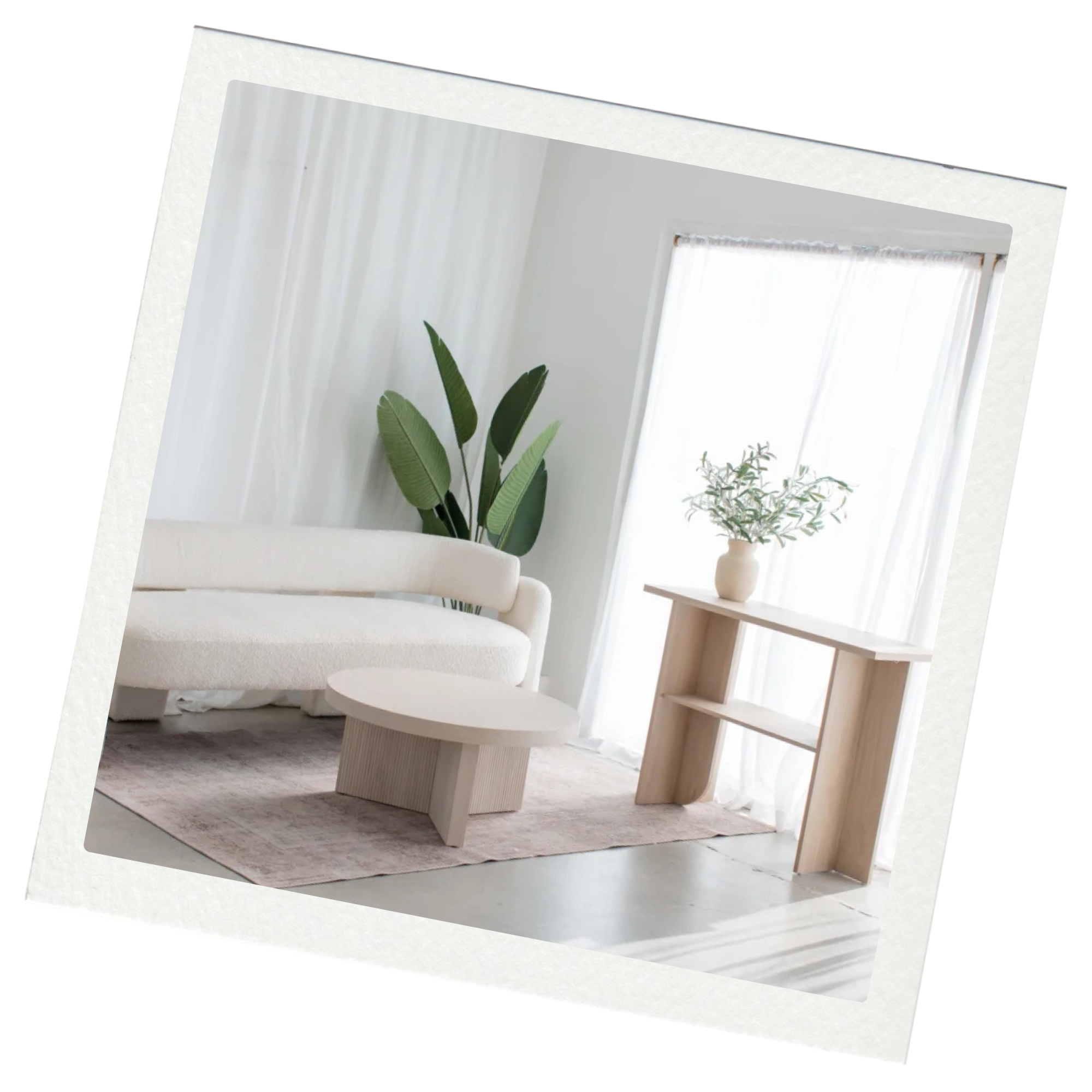 Minimalistic living room with a white sofa, a round coffee table, a wooden console table with a potted plant, tall green indoor plant, and sheer white curtains letting in natural light.