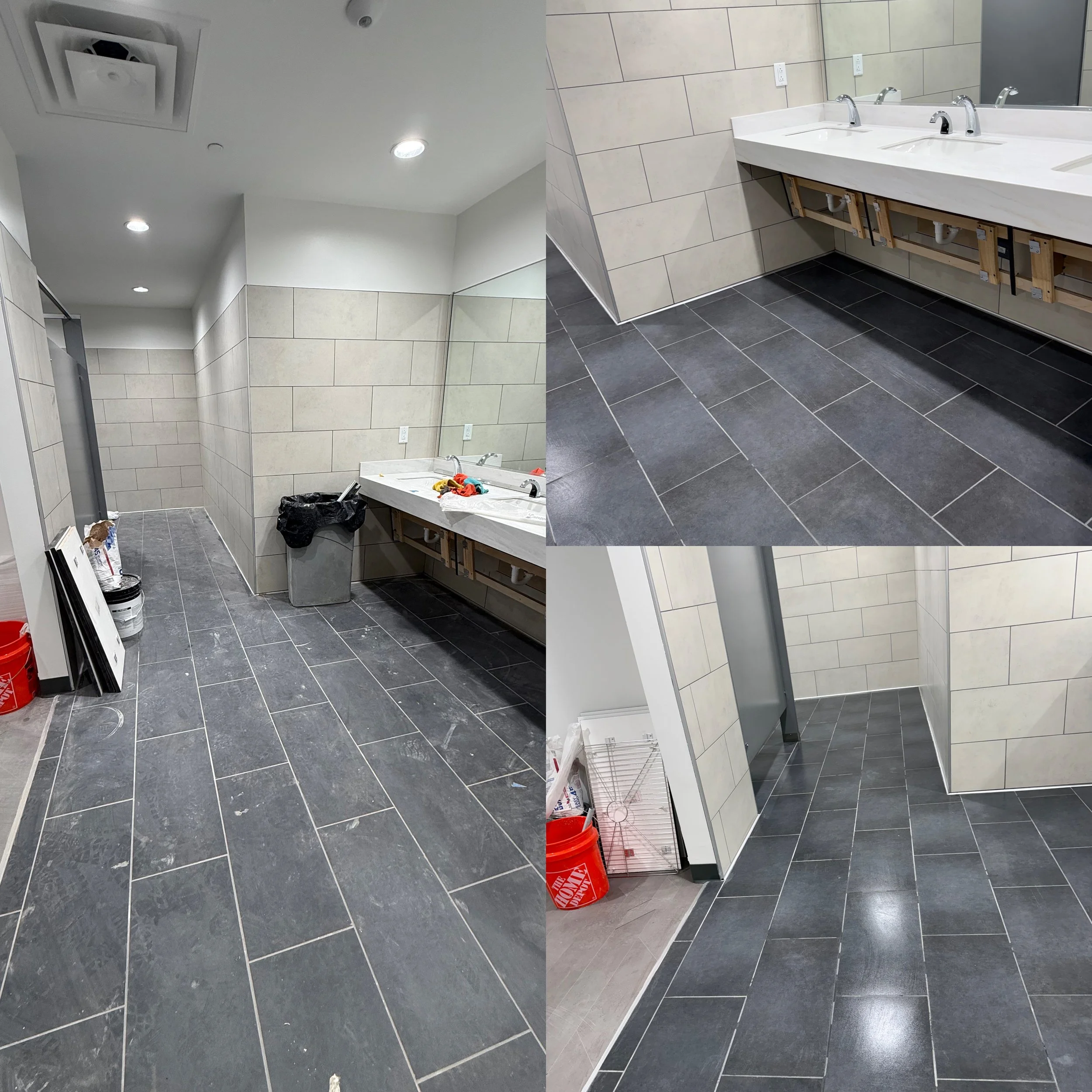 Construction site of a bathroom with tiled floors and partially finished sinks and walls.
