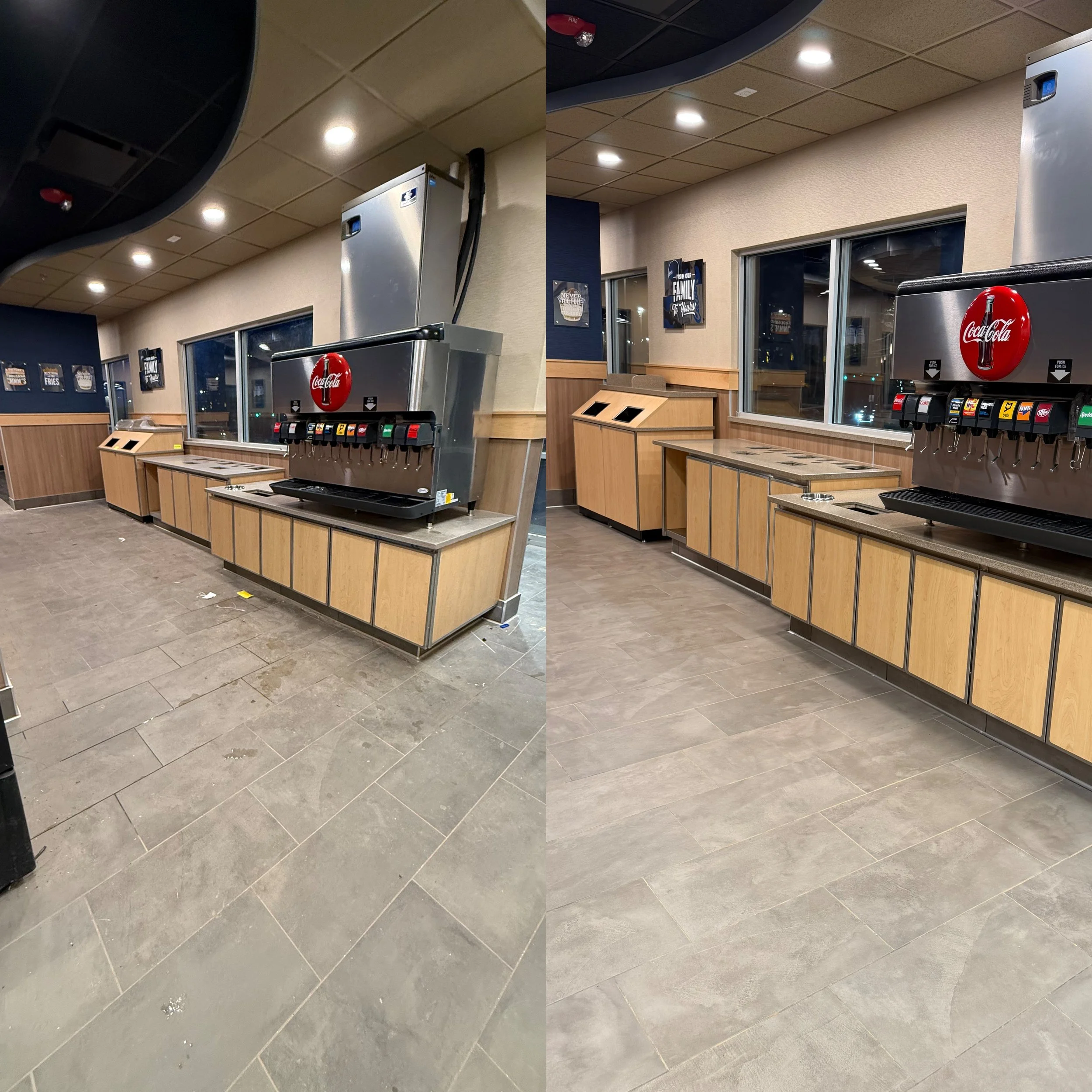 Empty fast-food soda fountain station with multiple soda dispensers and a countertop in a restaurant or cafe setting, with a window and framed pictures on the wall.