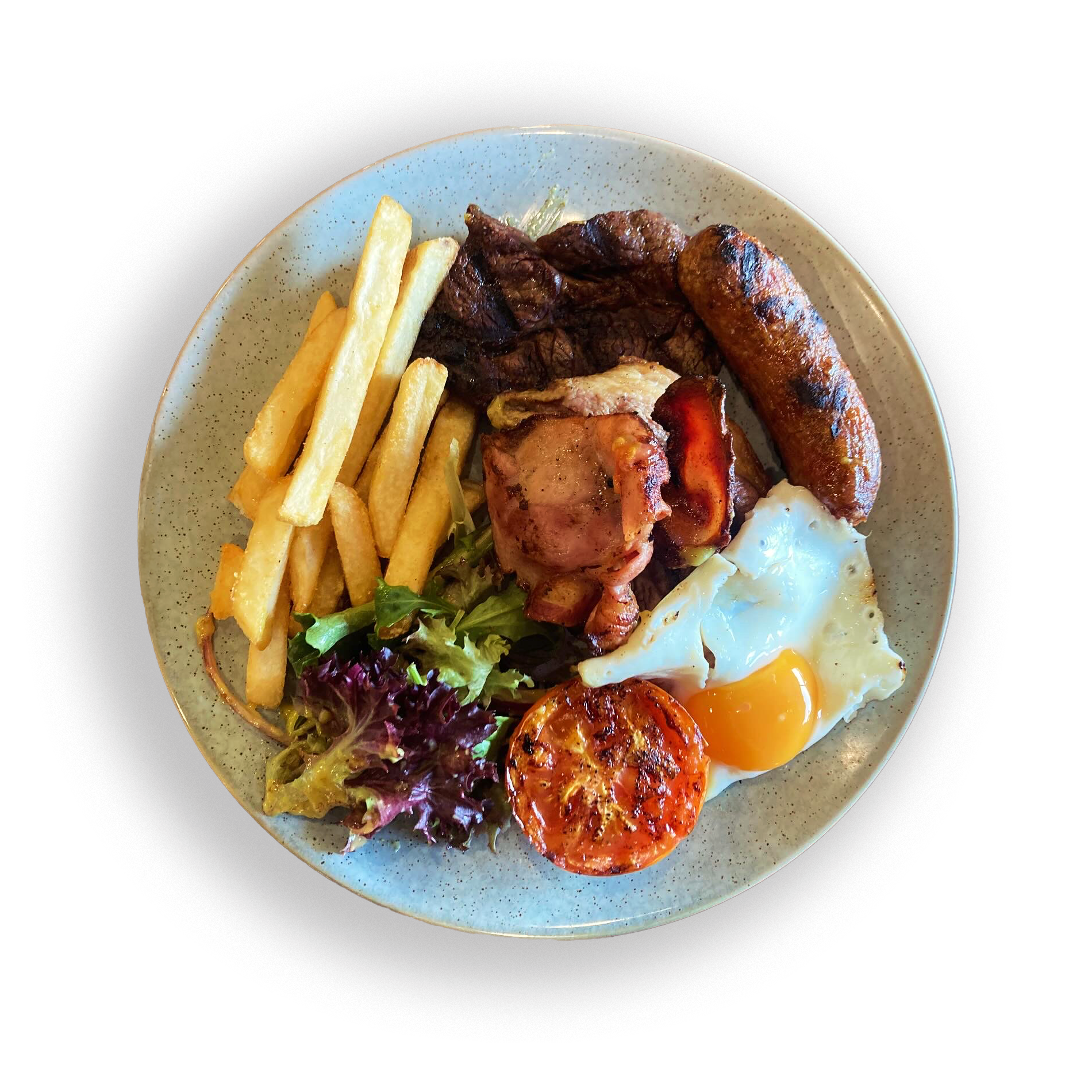 A plate of assorted breakfast foods including French fries, cooked meat, a sausage link, a sunny-side-up egg, grilled tomato, and some greens.