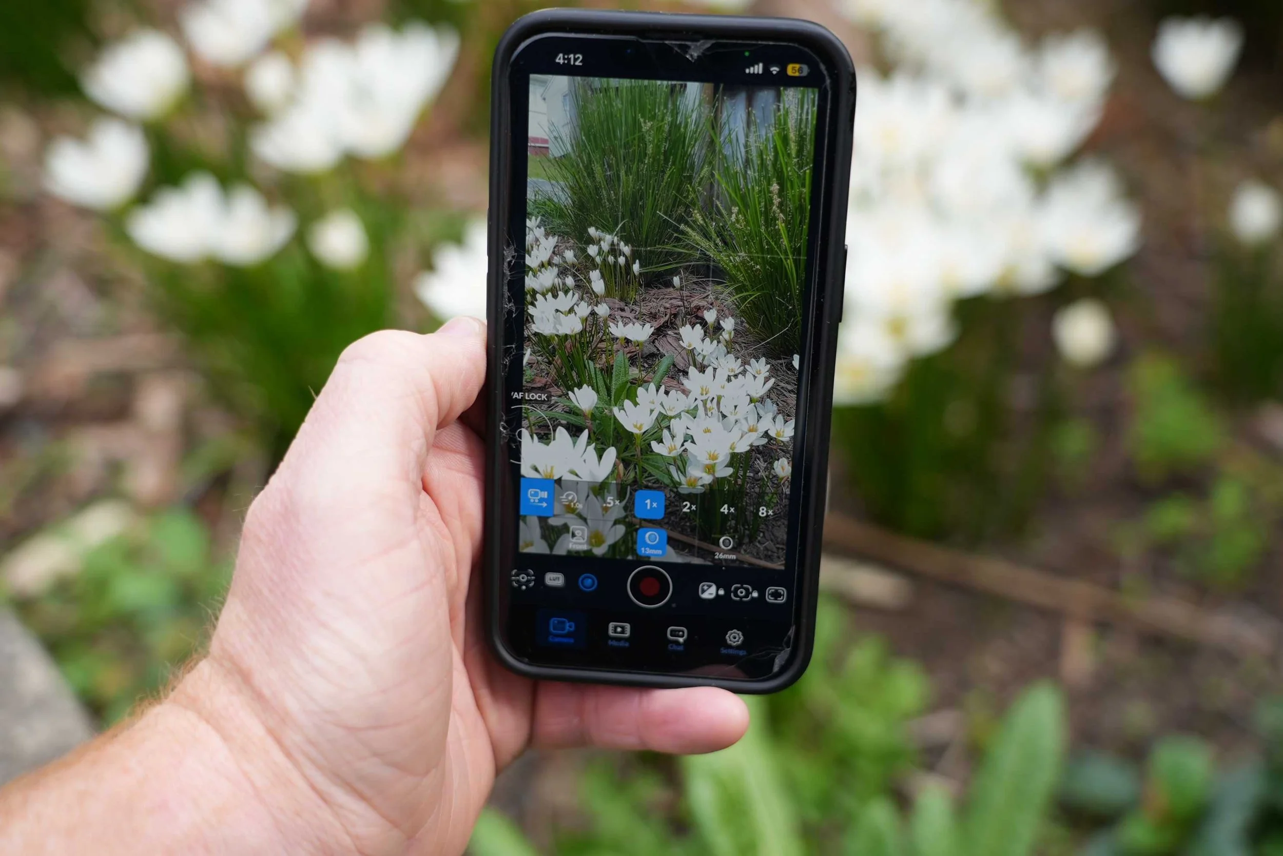 A hand holds an iPhone as it shoots video footage.