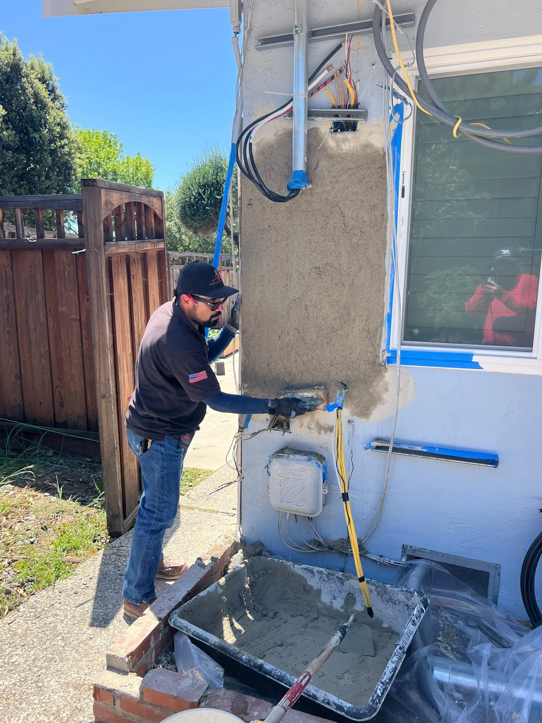 Wall repaired and re-stuccoed after panel replacement in San Jose by MH Electrical Services.