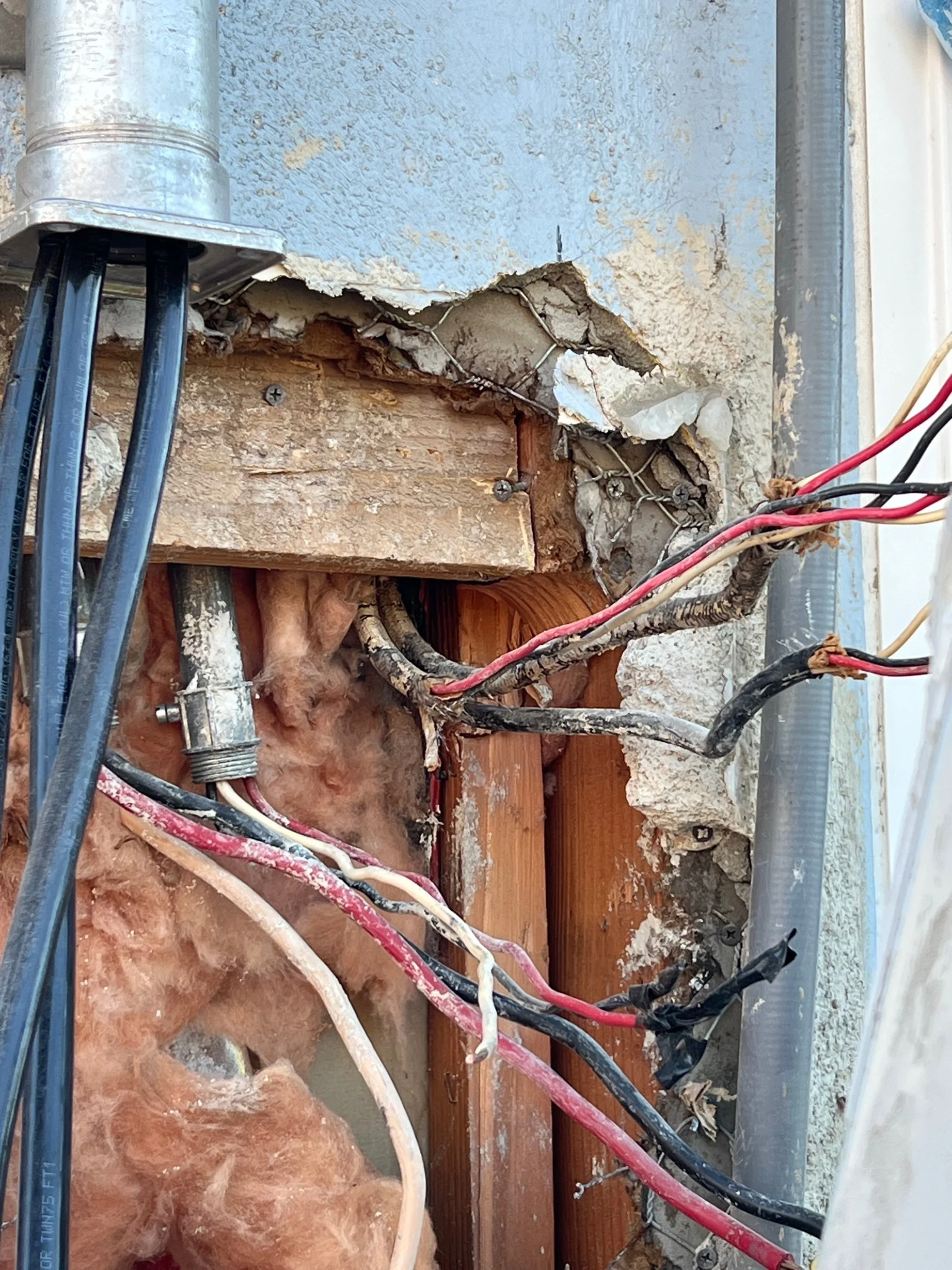 Heat-damaged cables hidden inside the wall in San Jose by MH Electrical Services.