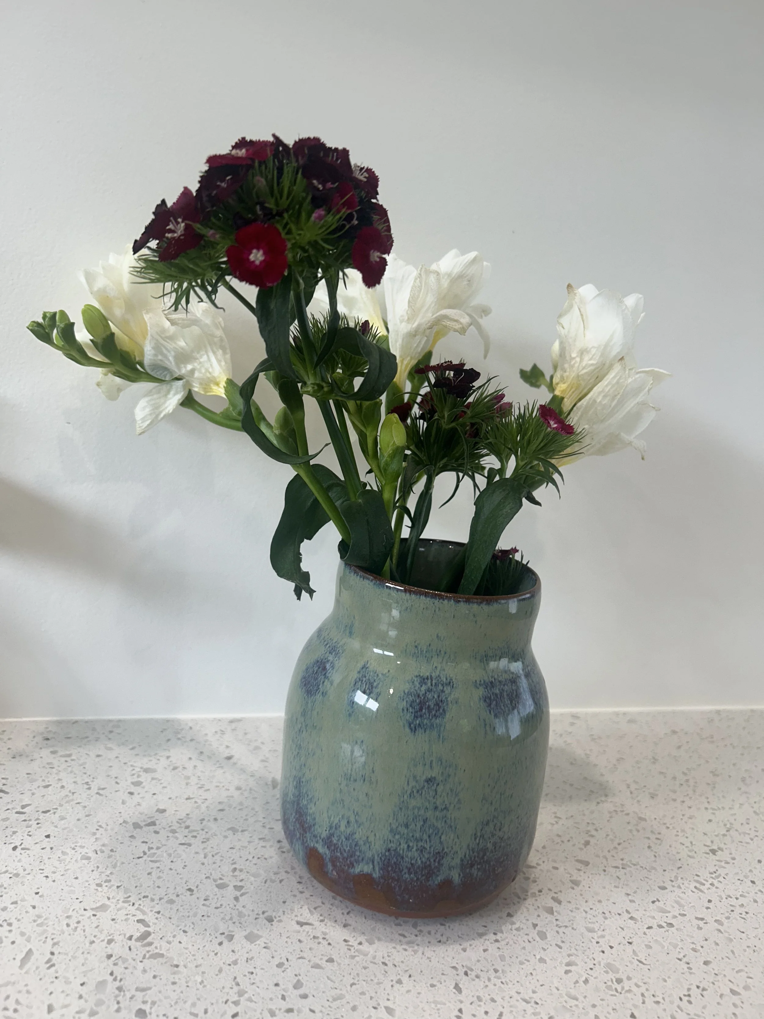 Green handmade vase with flowers