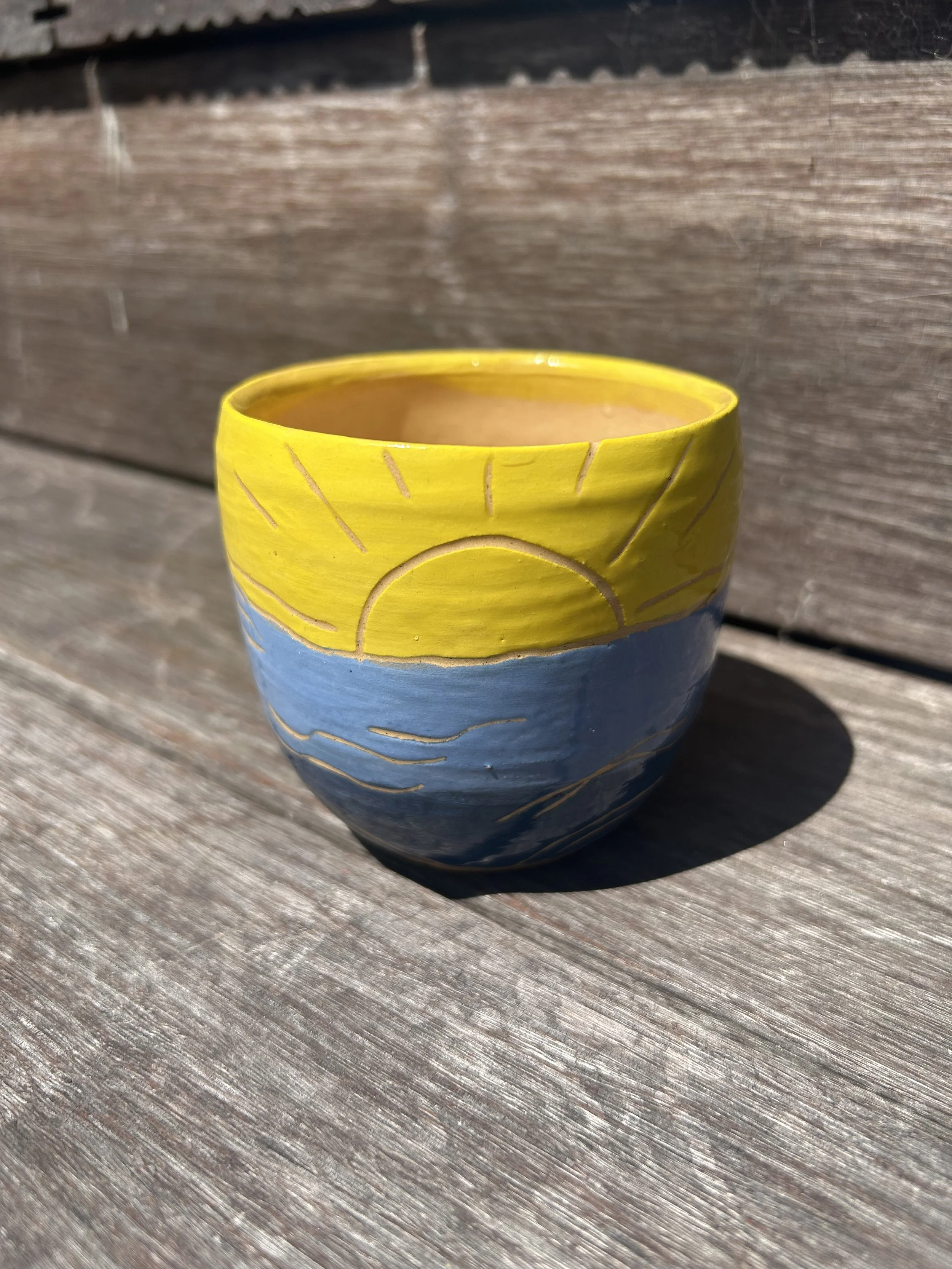A sunshine ocean themed ceramic coffee tumbler handmade by Wellington artist Cassie Callard