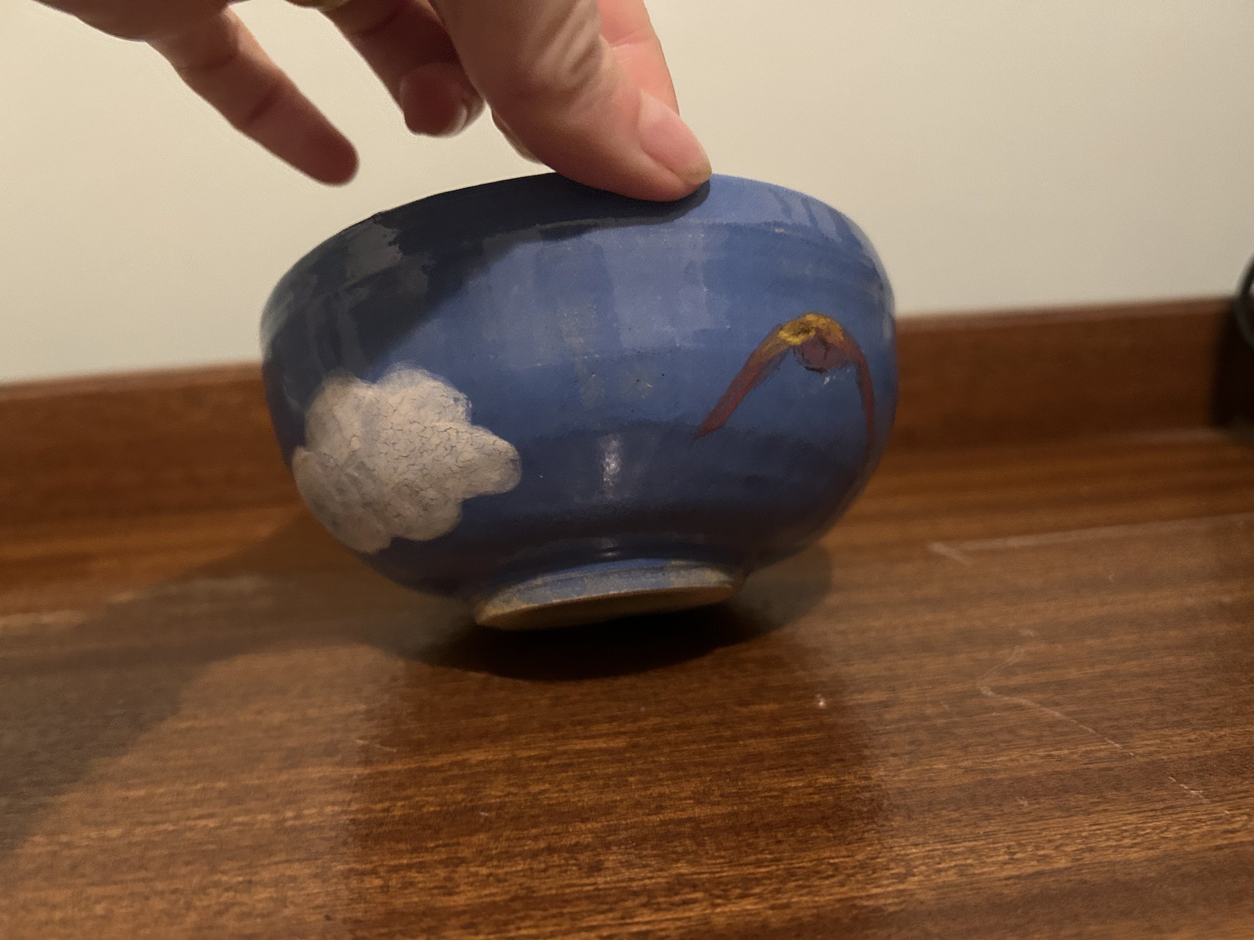 Blue handmade ceramic bowl with clouds and birds
