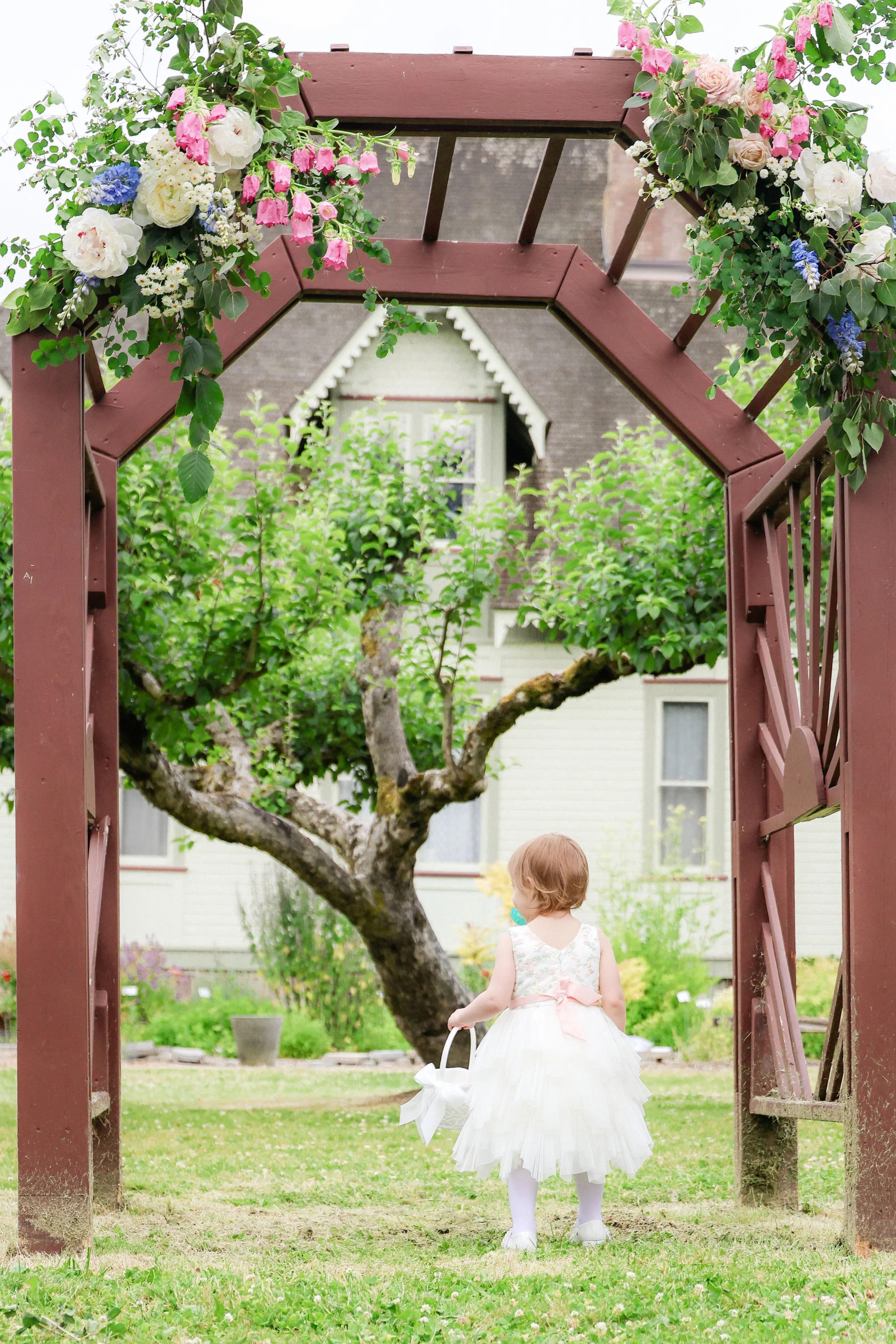 Pacific Northwest wedding garden archway — NYLEAR event photography capturing candid natural moments in Bellingham WA