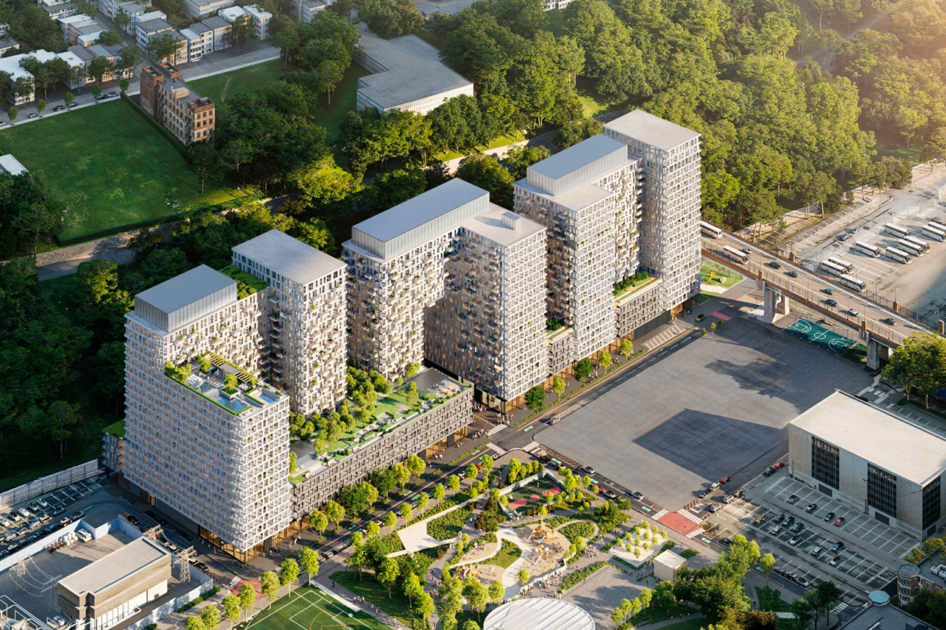 Aerial view of a modern residential complex with multiple high-rise buildings surrounded by green spaces, trees, and parks, with a parking lot and sports courts nearby.