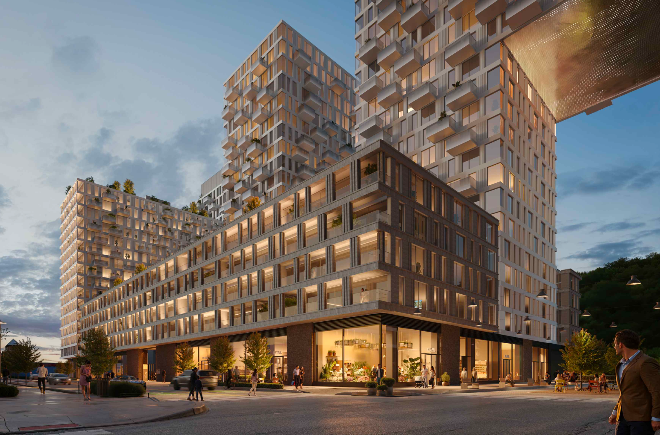 Modern multi-story building with residential units and retail shops on the ground floor, illuminated with warm lighting, as people walk and gather outside during dusk.
