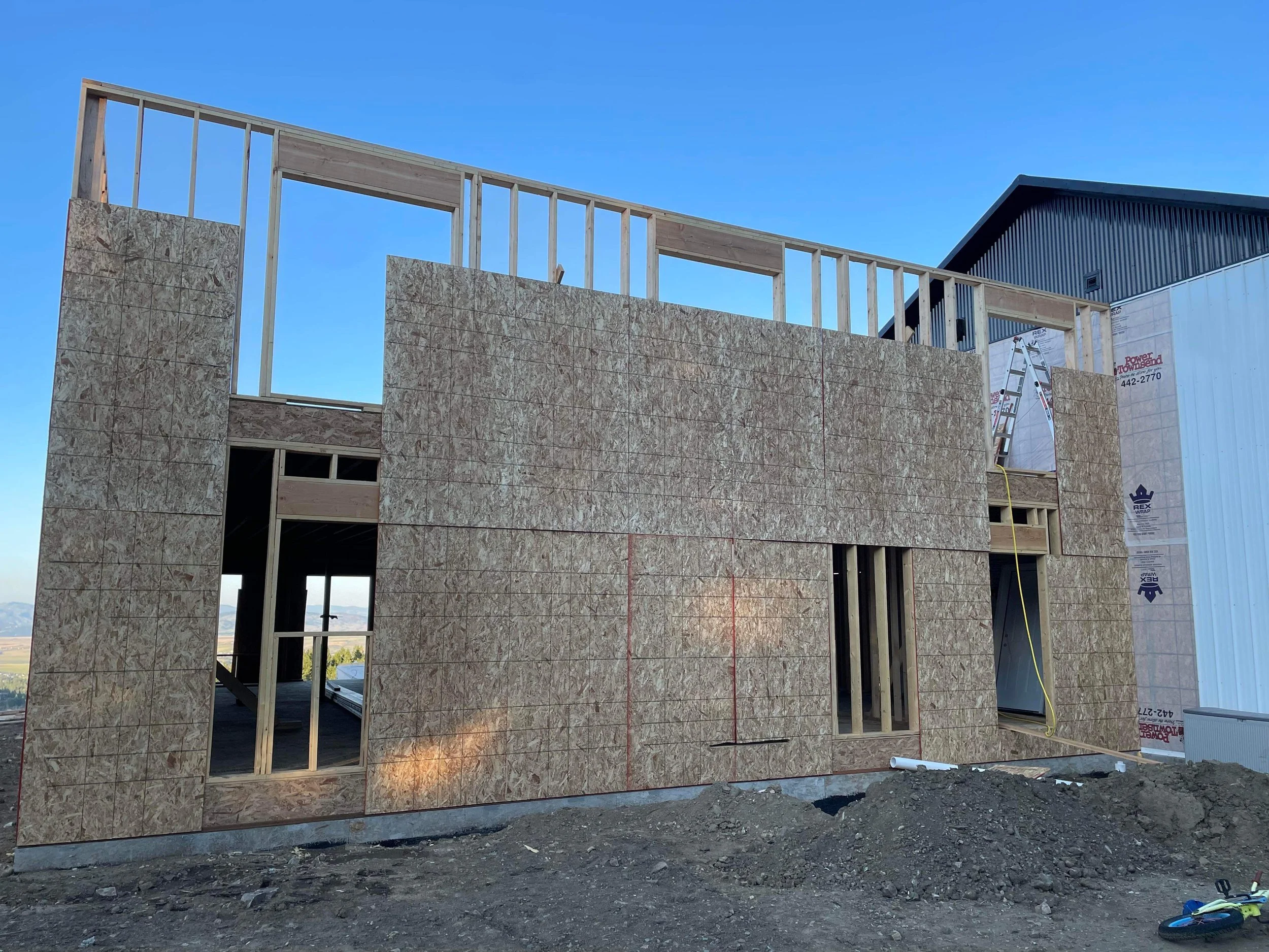 Residential framing and exterior sheathing work during early build phase. 