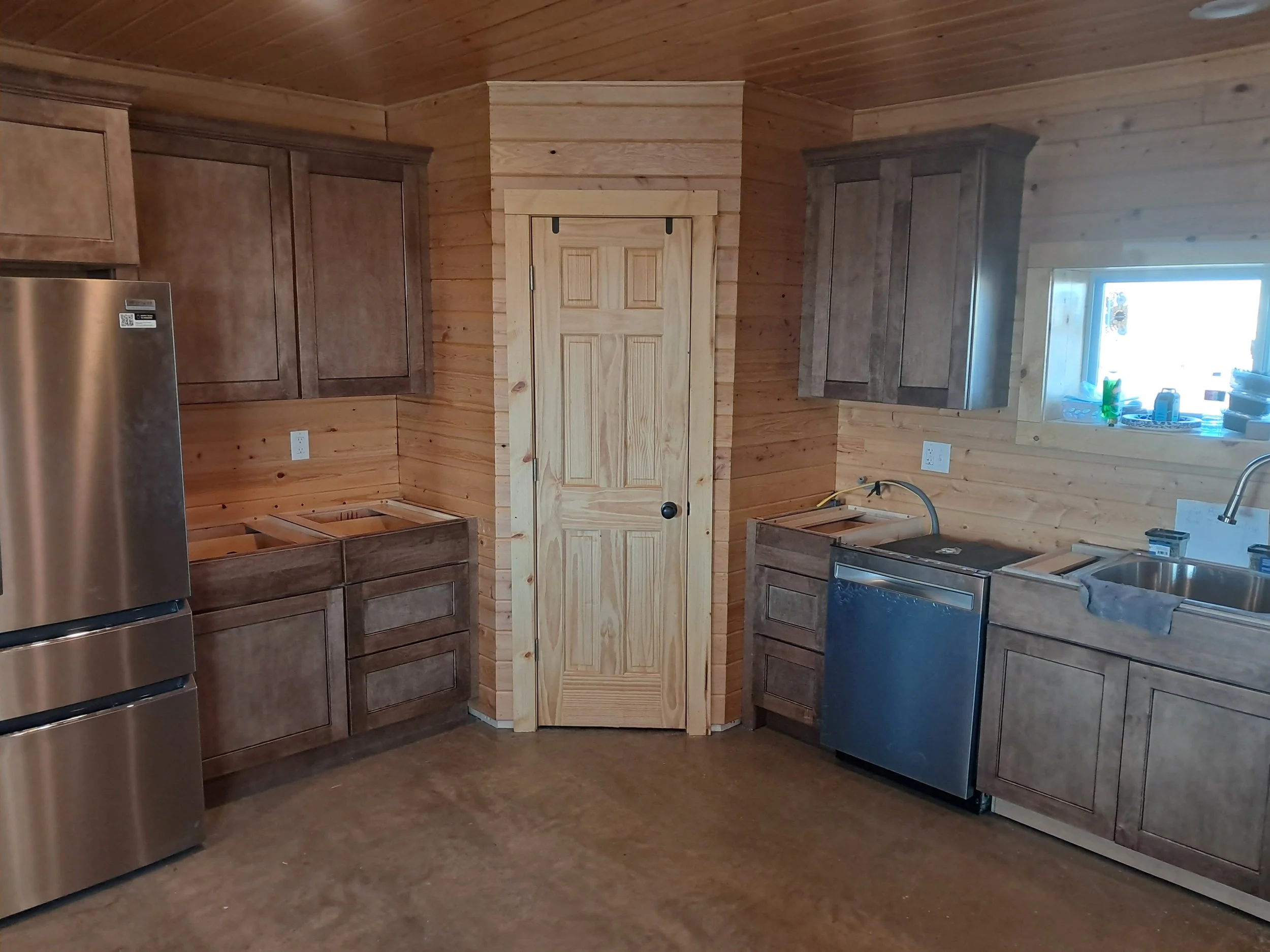 Custom pantry door centered within the kitchen, framed y tongue and groove wood walls for a cohesive, all-wood interior per clients request. 
