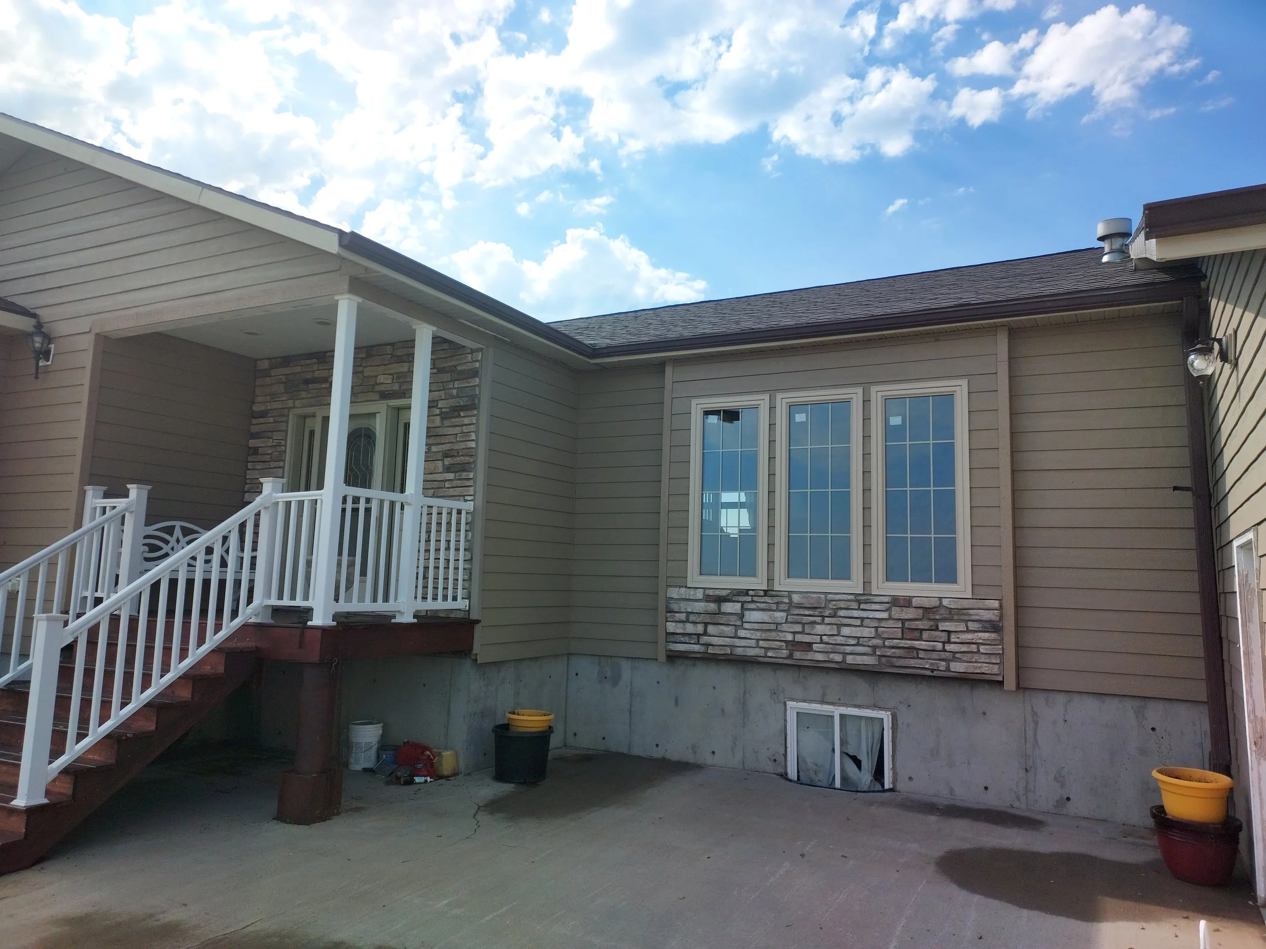 Residential exterior siding updates including front porch soffit and exterior lighting installation. 