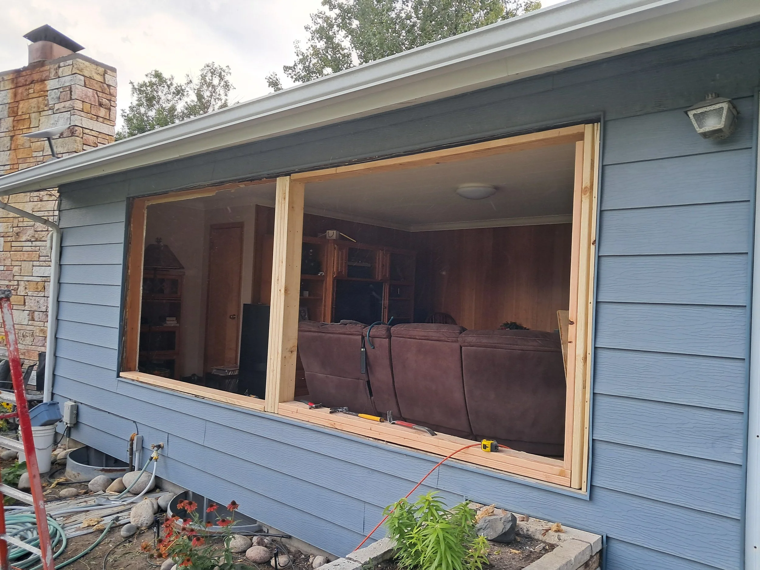 Window installation in progress on a house  with wooden framing by Zilkoski Construction LLC.
