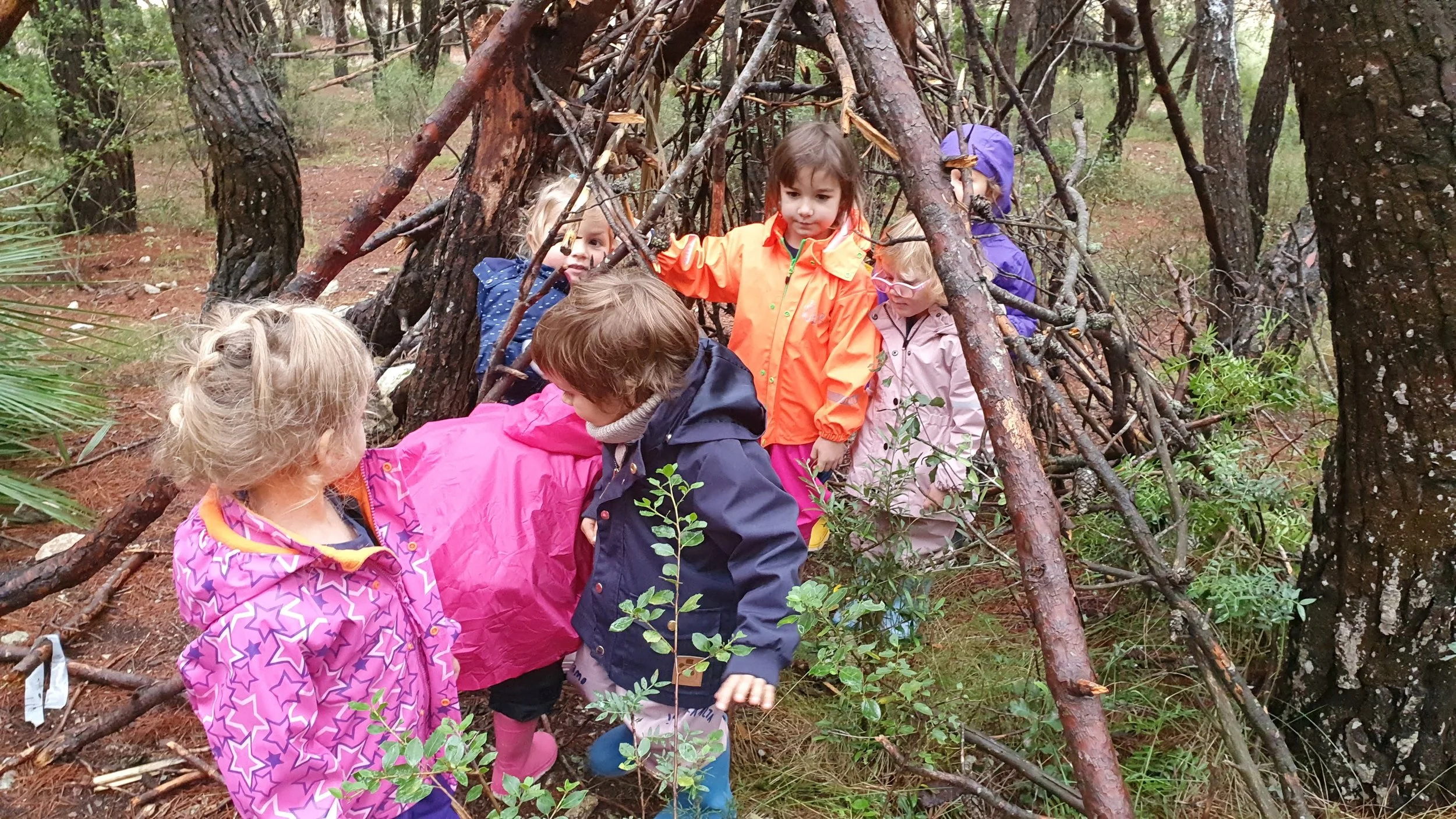 Walking outdoors through teepees built with branches