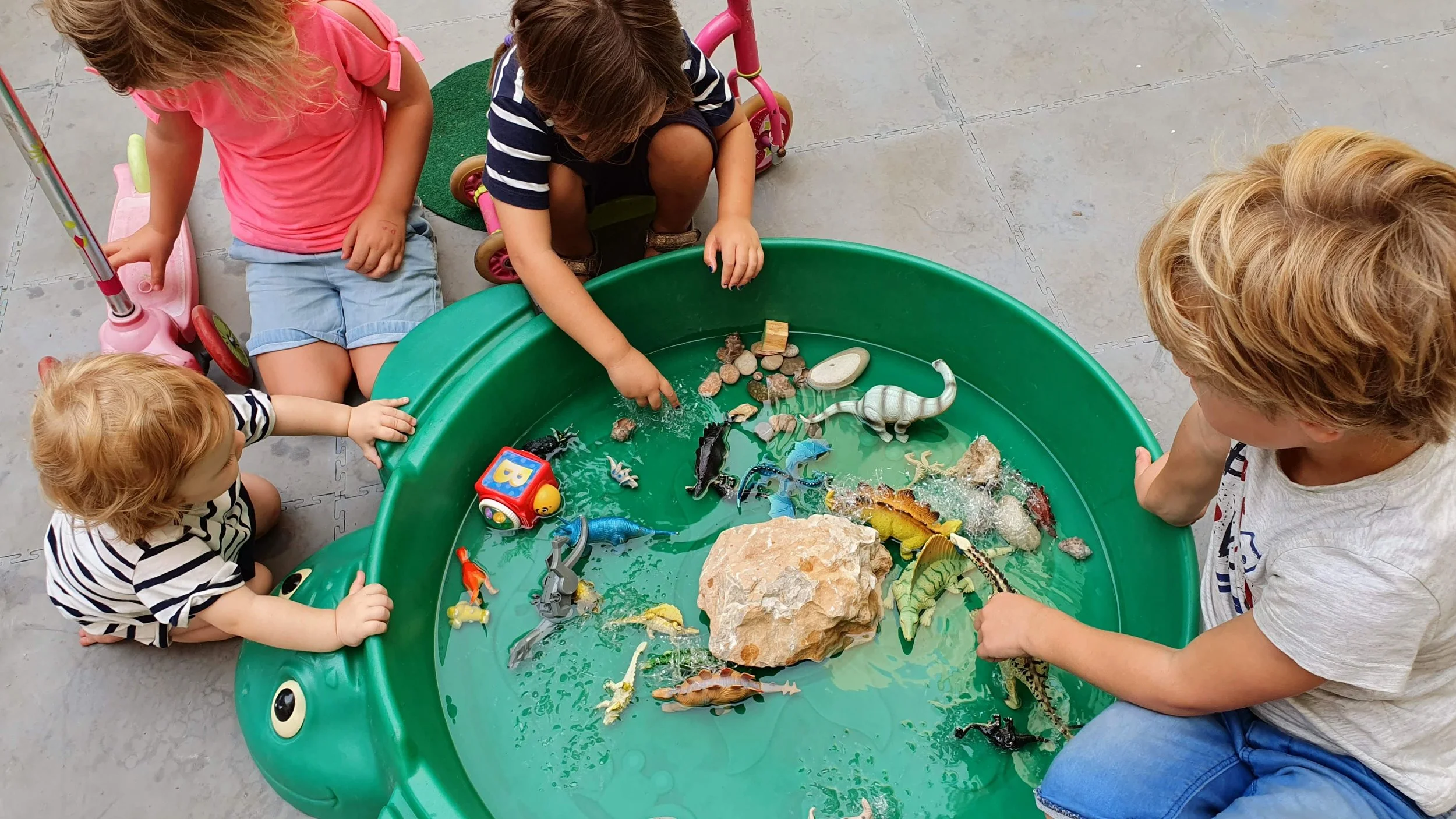 Kids playing with toys in a a kiddie pool