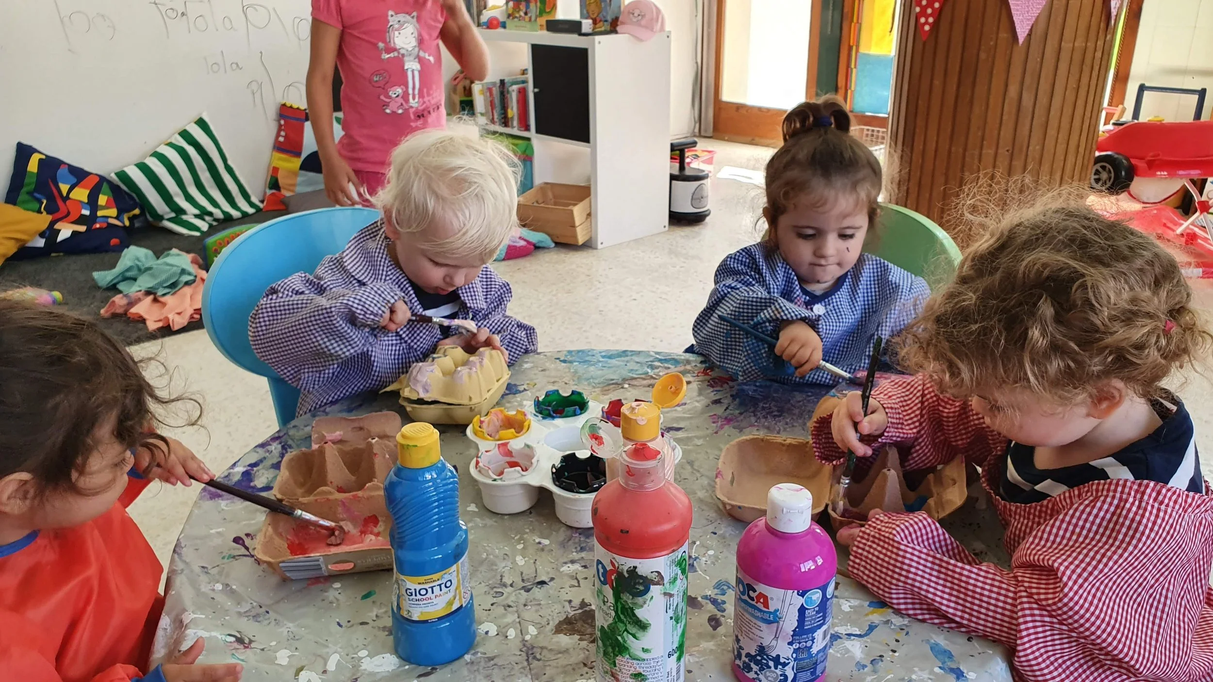 Toddlers painting egg cartons